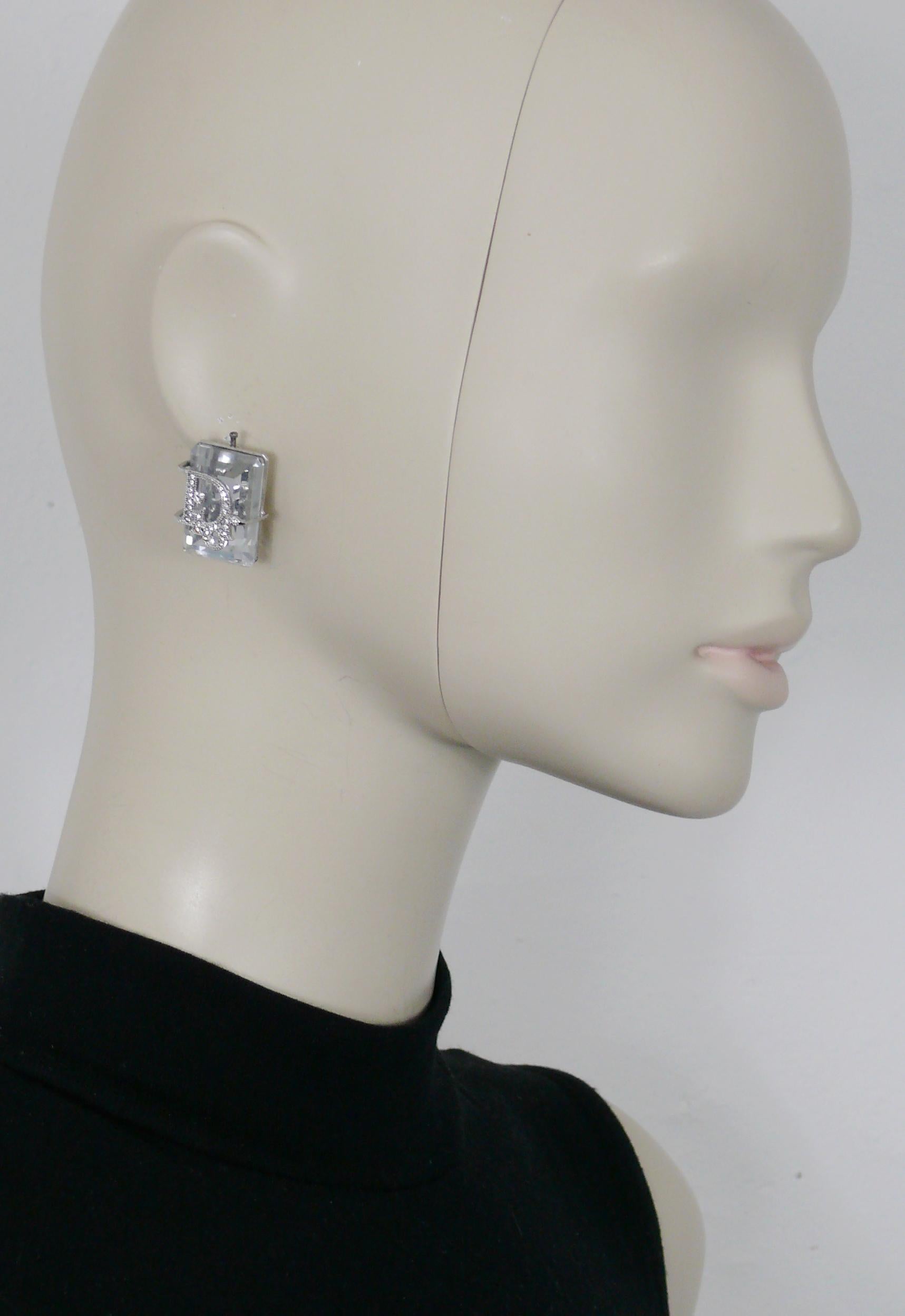CHRISTIAN DIOR Ohrringe im Vintage-Stil mit einem massiven, rechteckigen, klaren Kristall, der in ein mit Juwelen besetztes DIOR-Logo eingefasst ist.

Silberfarbene Metallbeschläge.

Geprägte DIOR.

Ungefähre Maße: ca. 2,5 cm x 1,7 cm (0,98 Zoll x
