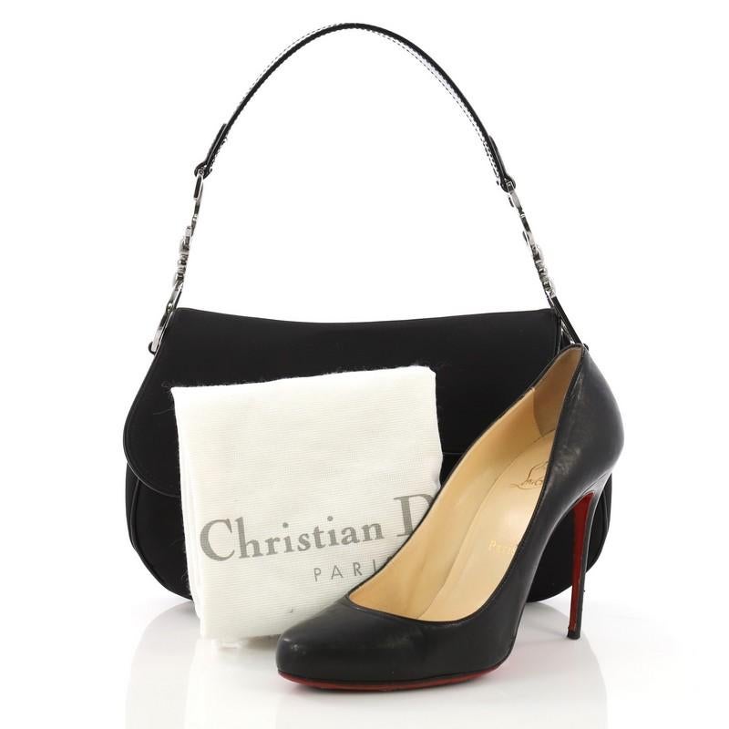 This Christian Dior Vintage Double Saddle Bag Nylon, crafted from black nylon, features a top handle adorned with metal 'CD' finishing and silver-tone hardware. Its fold over top opens to a black nylon interior with zip pocket. **Note: Shoe