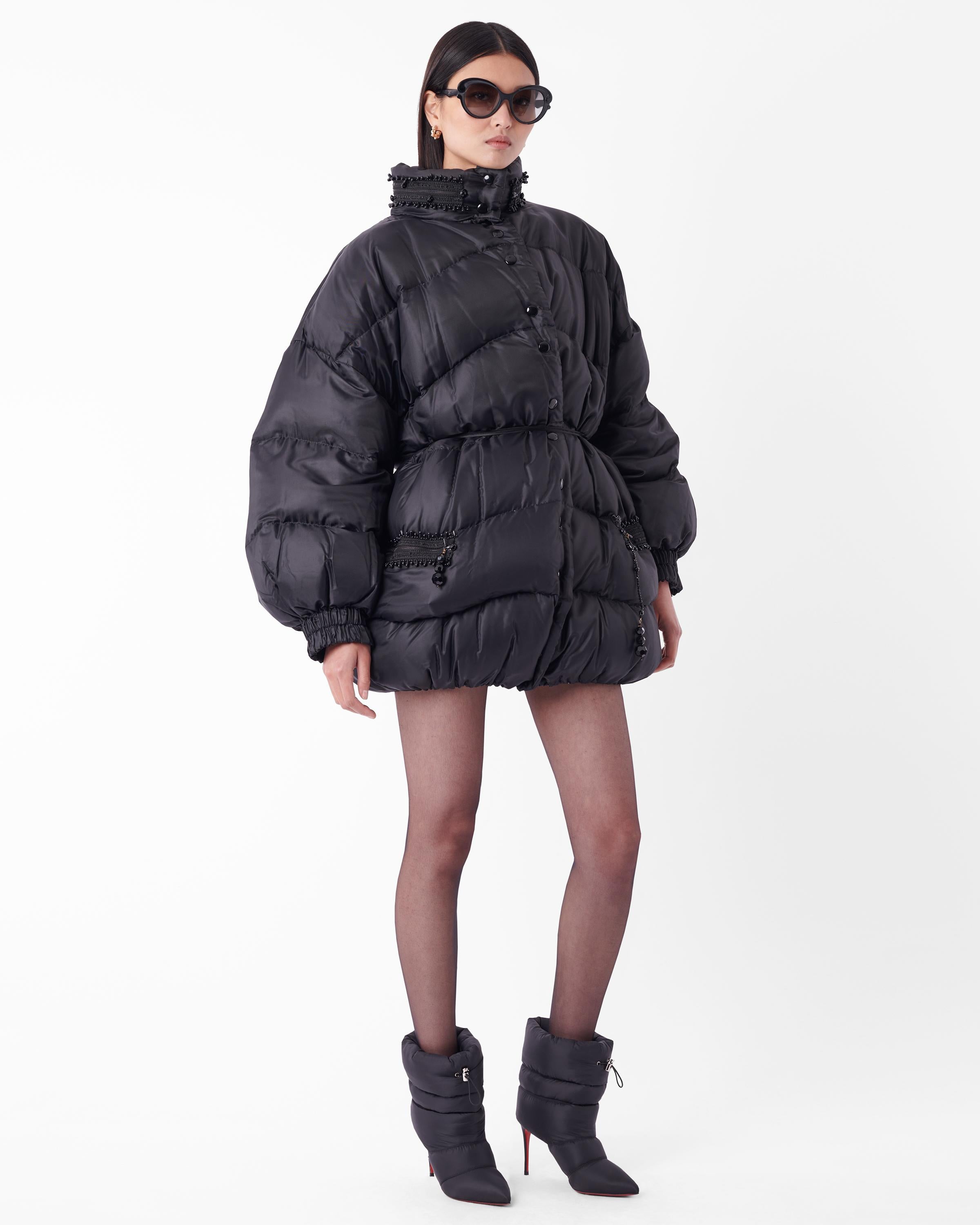 Vintage Christian Dior black beaded oversized puffer jacket. Features black beaded ornaments around the neckline with two side zip pockets, and comes with a thin satin belt to curve and accentuate the silhouette and waistline with front button