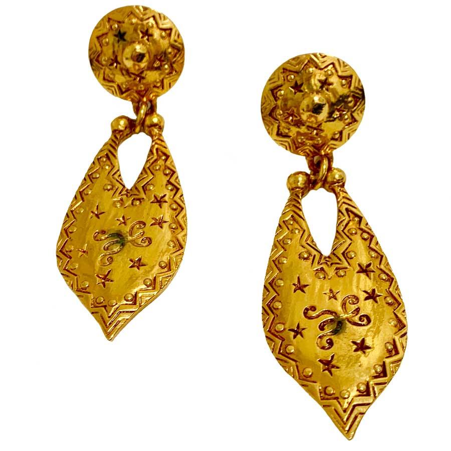 Find here a pair of hammered golden metal clip earrings, with stars and various engraved patterns. They have a real vintage look from the 90s that we love.
The earrings are in good condition. We can however see on the photos, a little black in the