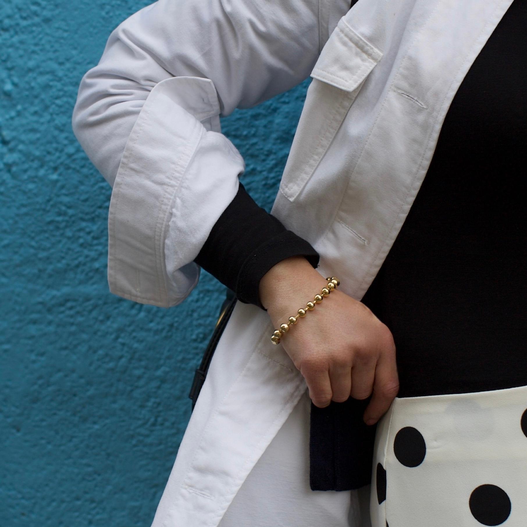 A refined vintage Christian Dior bracelet dating to the 1960s, designed in polished gold-coloured metal and composed of uniform 7 mm spherical beads. The elegant simplicity of the design is enhanced by the warm gold finish, reflecting Dior’s