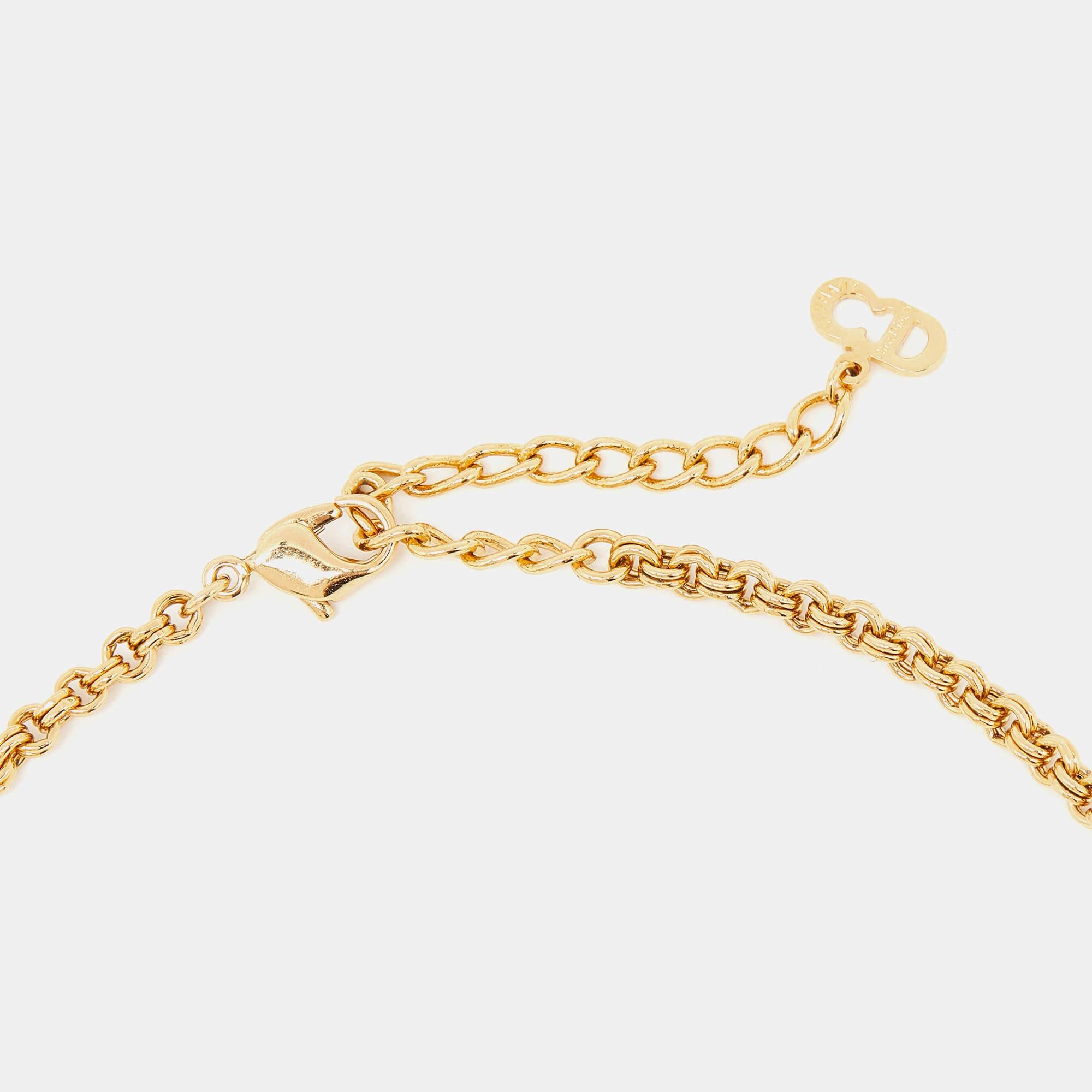 Schmücken Sie sich mit der zeitlosen Eleganz der Vintage-Halskette von Christian Dior. Dieses exquisite, mit viel Liebe zum Detail gefertigte Schmuckstück besteht aus einer glänzenden, goldfarbenen Kette, die mit schillernden Strasssteinen besetzt