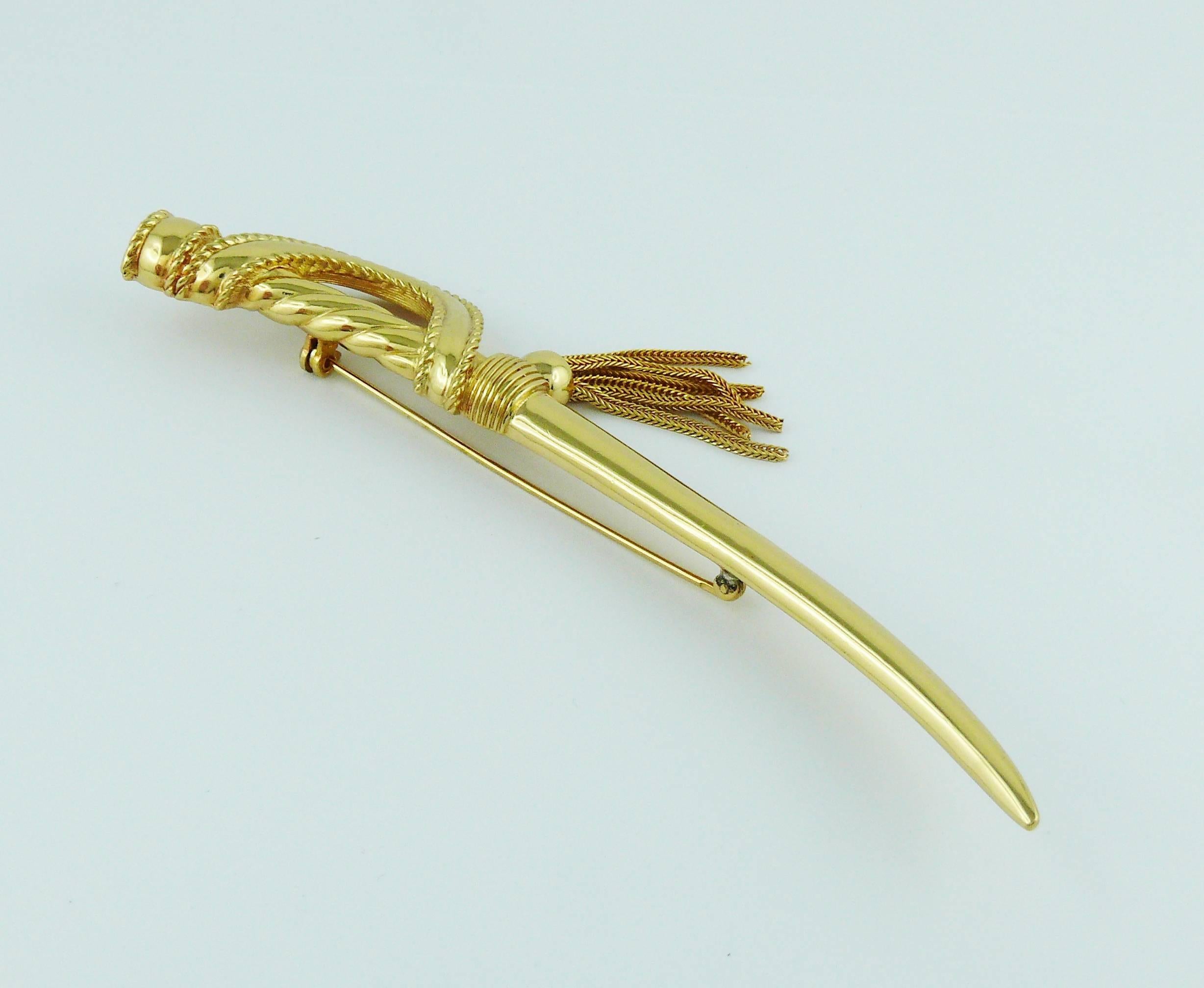 CHRISTIAN DIOR vintage gold toned brooch featuring a saber sword with tassel detail.

Marked CHR. DIOR ©.

Indicative measurements : length approx. 12 cm (4.72 inches).

JEWELRY CONDITION CHART
- New or never worn : item is in pristine condition