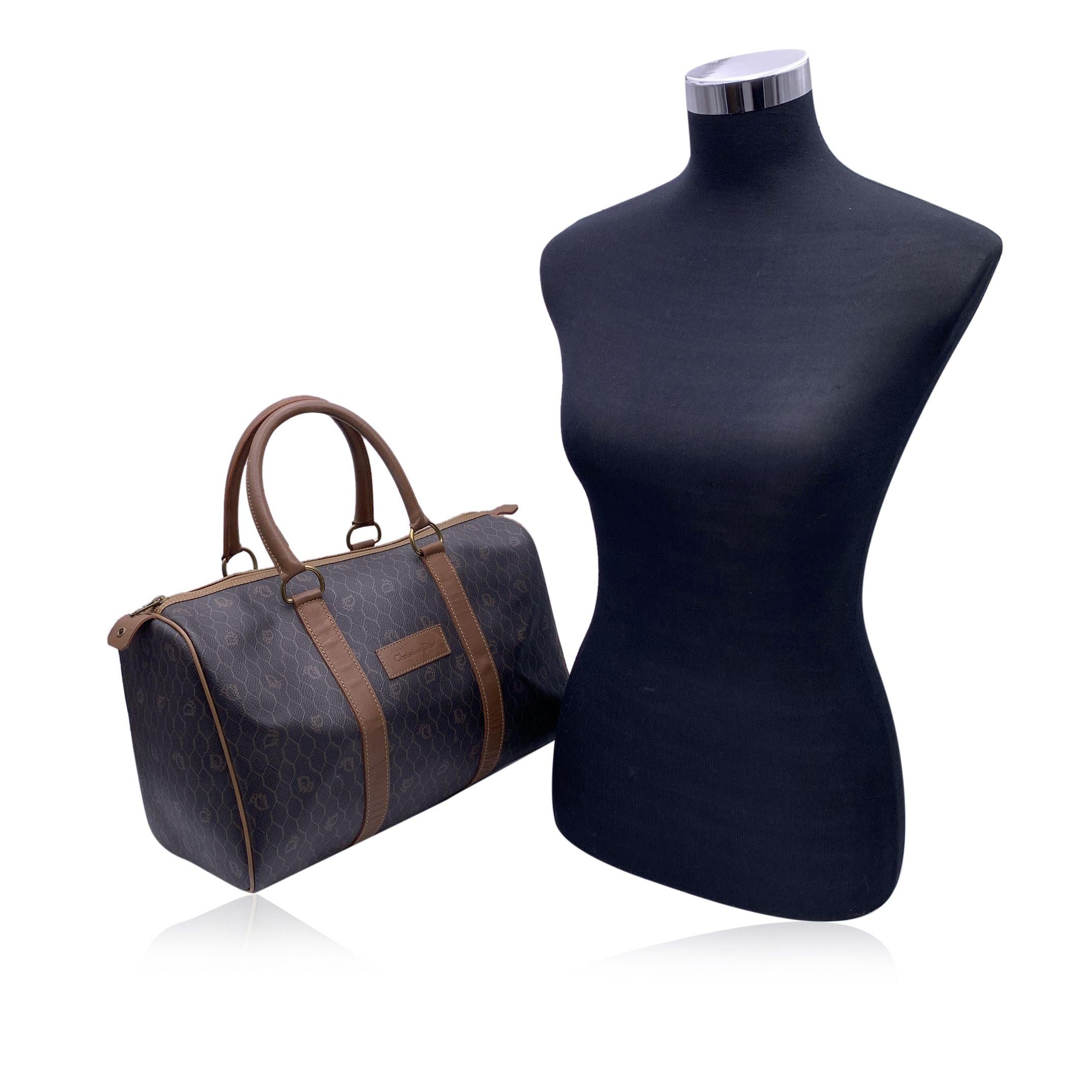 Vintage boston bag by Christian Dior. Dior brown monograms over charcoal canvas, with brown leather trim and finish. Top leather handles, no strap. Upper zipper closure. 1 side zip pocket inside. 'Christian Dior - Made in France' gold metal tag