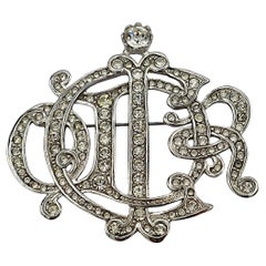 CHRISTIAN DIOR Broche vintage avec monogramme et logo, ornée de bijoux argentés