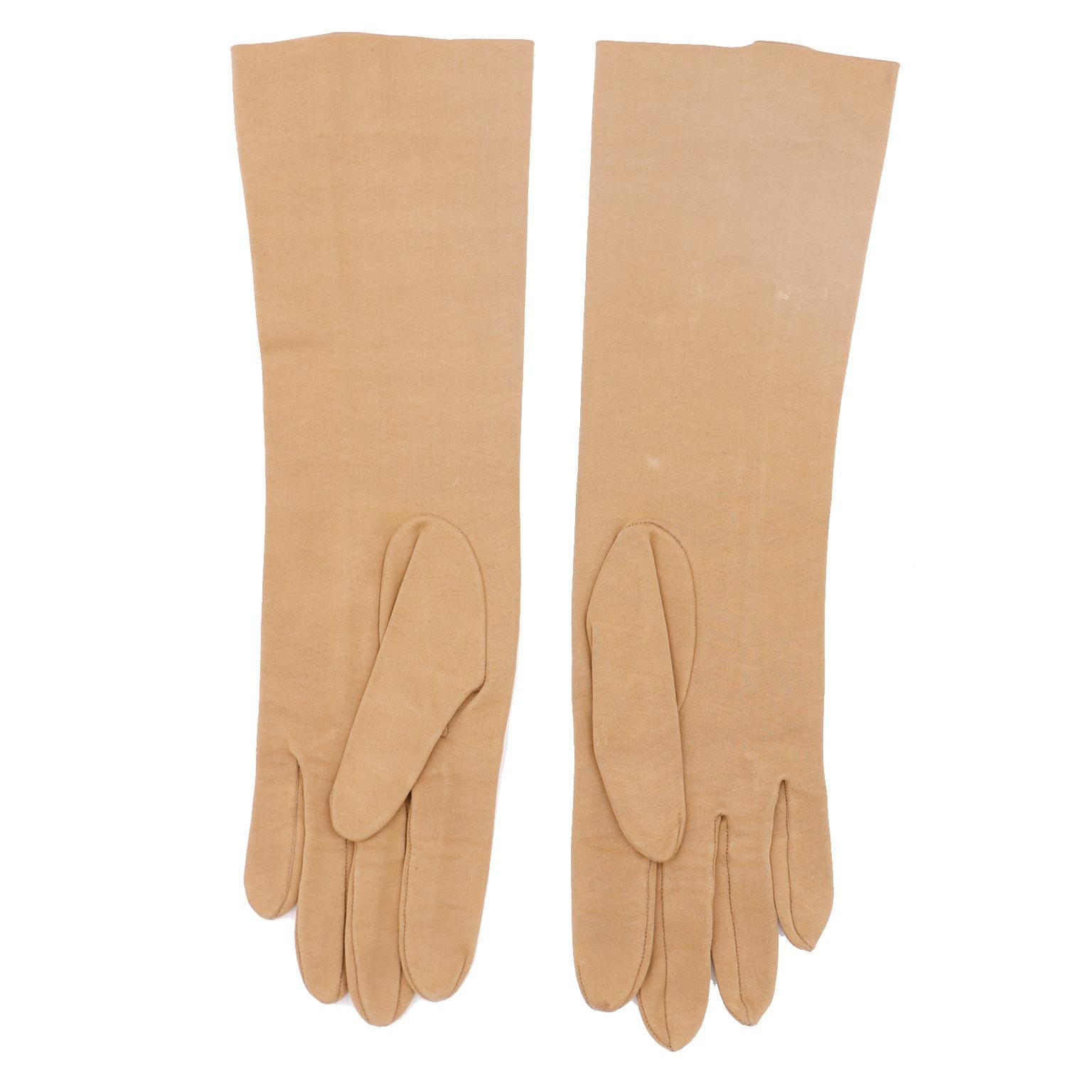 This is a lovely pair of vintage Christian Dior Sea Island cotton gloves from the 1970's. The gloves are in a pretty lighter brown beige color and were made in France. There is decorative top-stitching from the middle finger to the hem
- 1.5