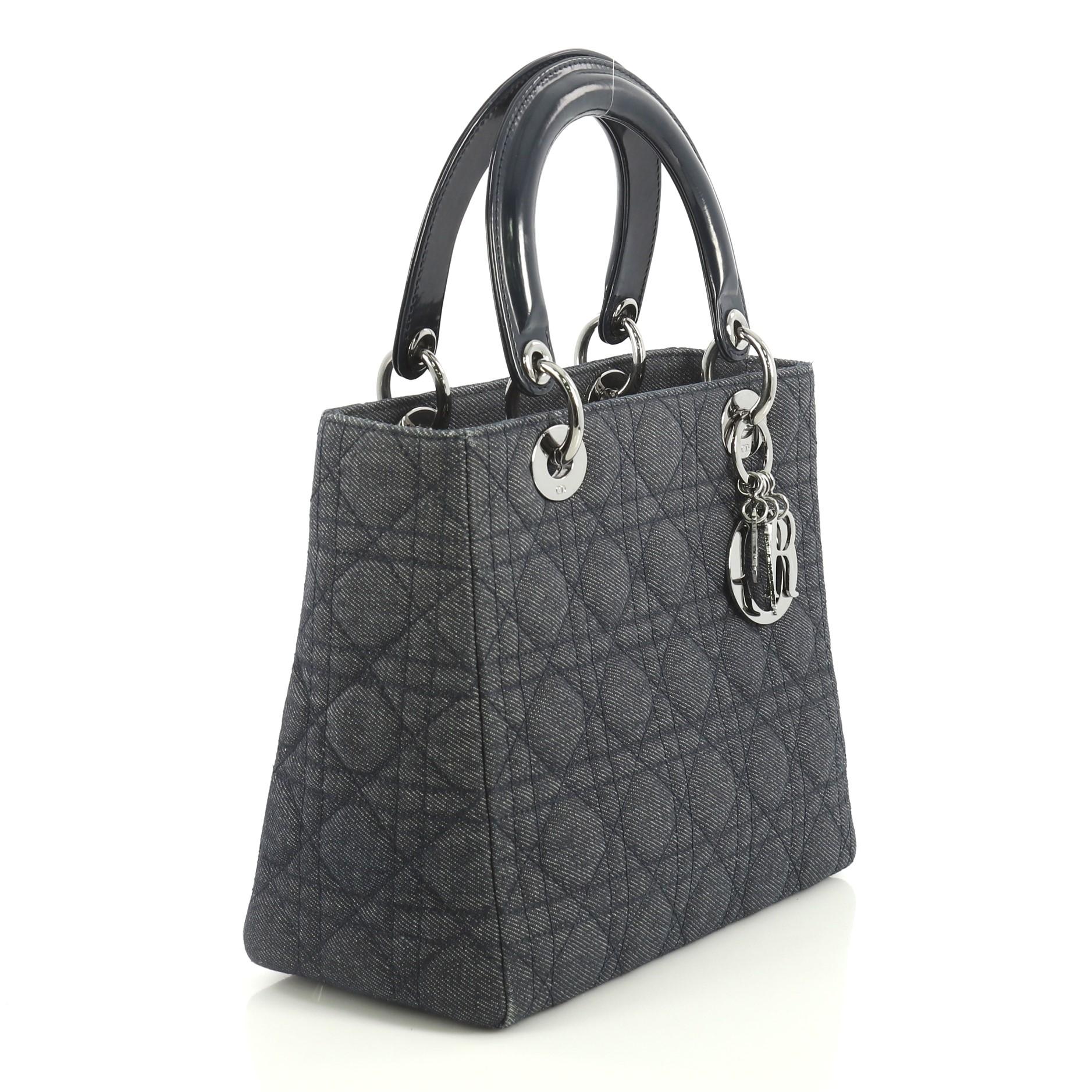 This Christian Dior Vintage Lady Dior Handbag Cannage Quilt Denim Medium, crafted in blue cannage quilted denim, features short dual handles with Dior charms and gunmetal-tone hardware. Its zip closure opens to a blue fabric interior with zip
