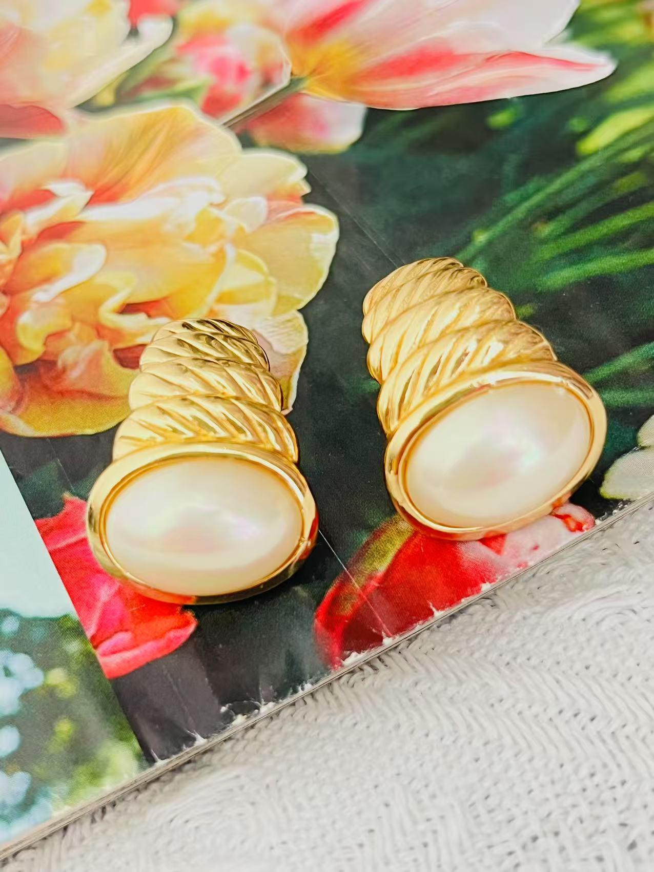 Christian Dior Vintage 1980s Große Ovale Weiße Perle Muschel Meeresschnecke Halbe Kuppel Hoop Elegante Modernistische Klobige Clip-Ohrringe, Gold-Ton

Sehr guter Zustand. Leichte Kratzer am Metall, leichter Farbverlust auf der Rückseite, kaum