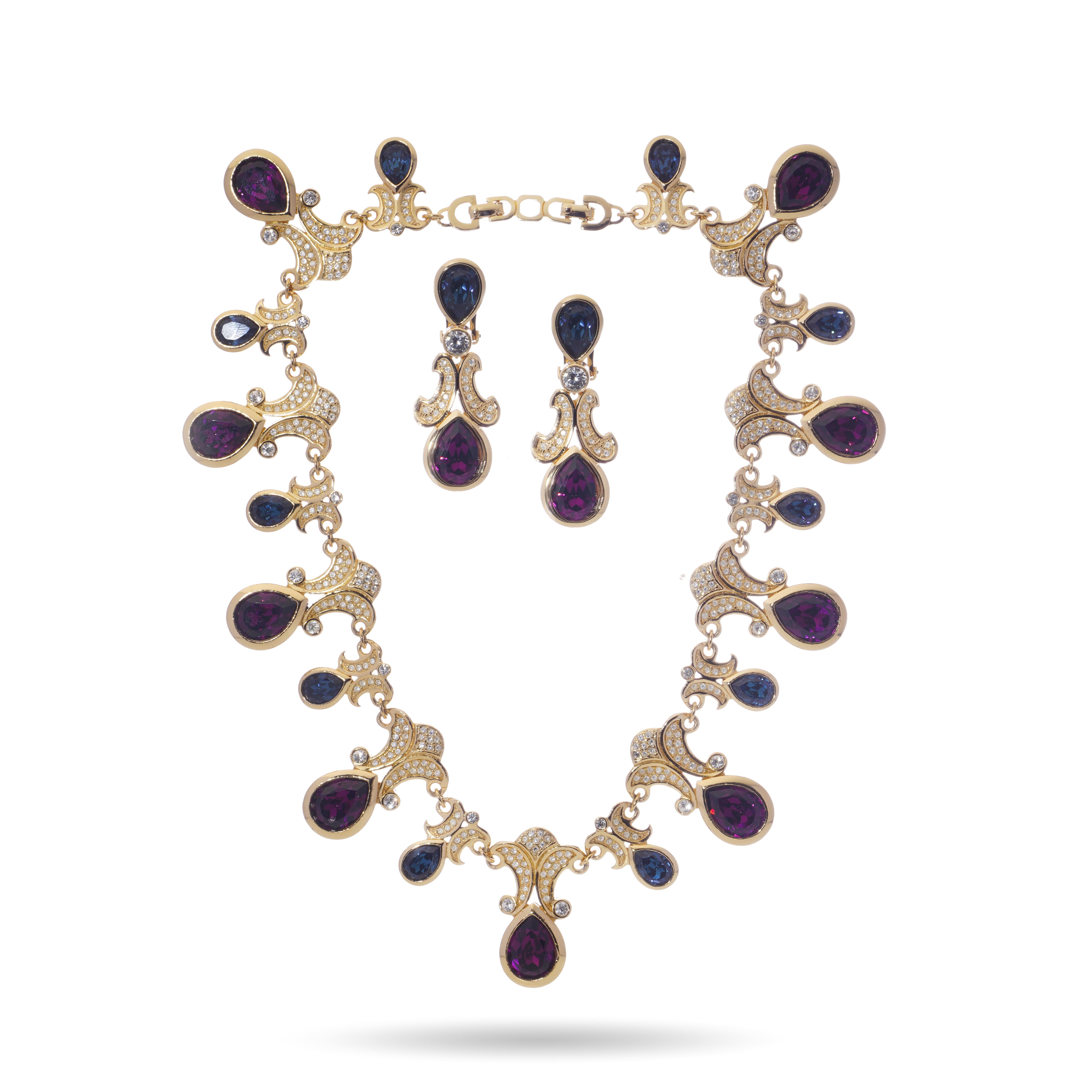 An exceptional Christian Dior vintage jewellery set from circa 1980s, comprising a statement necklace and matching convertible day-to-night earrings. The necklace is crafted in a gold tone finish, designed with cascading drops set with deep purple