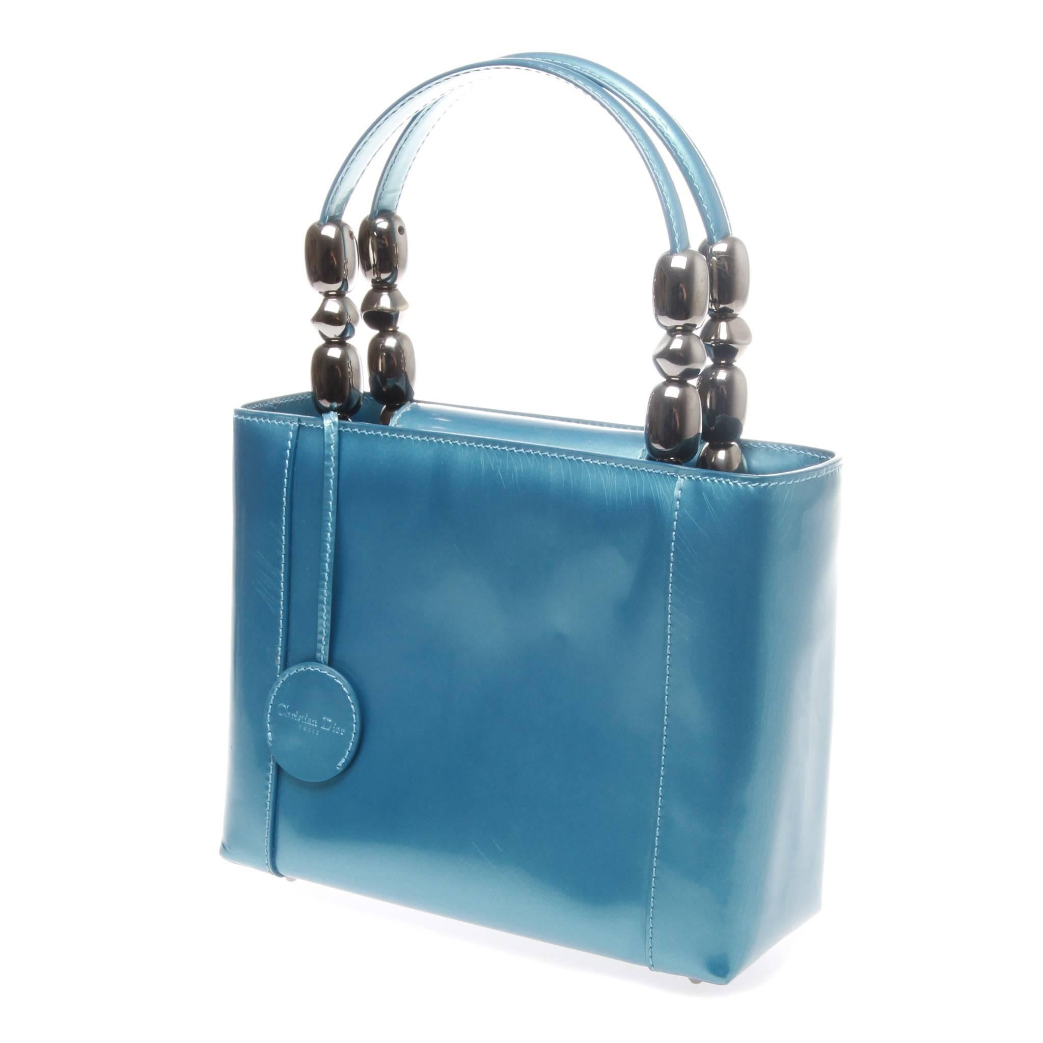 CHRISTIAN DIOR VINTAGE PATENT LEATHER MARIS PEARL HANDBAG 

A vintage patent leather maris pearl handbag by CHRISTIAN DIOR.
Stunning vintage blue patent leather with maris pearl handle, flap closure and interior zip pocket.

Handle drop: 4.75