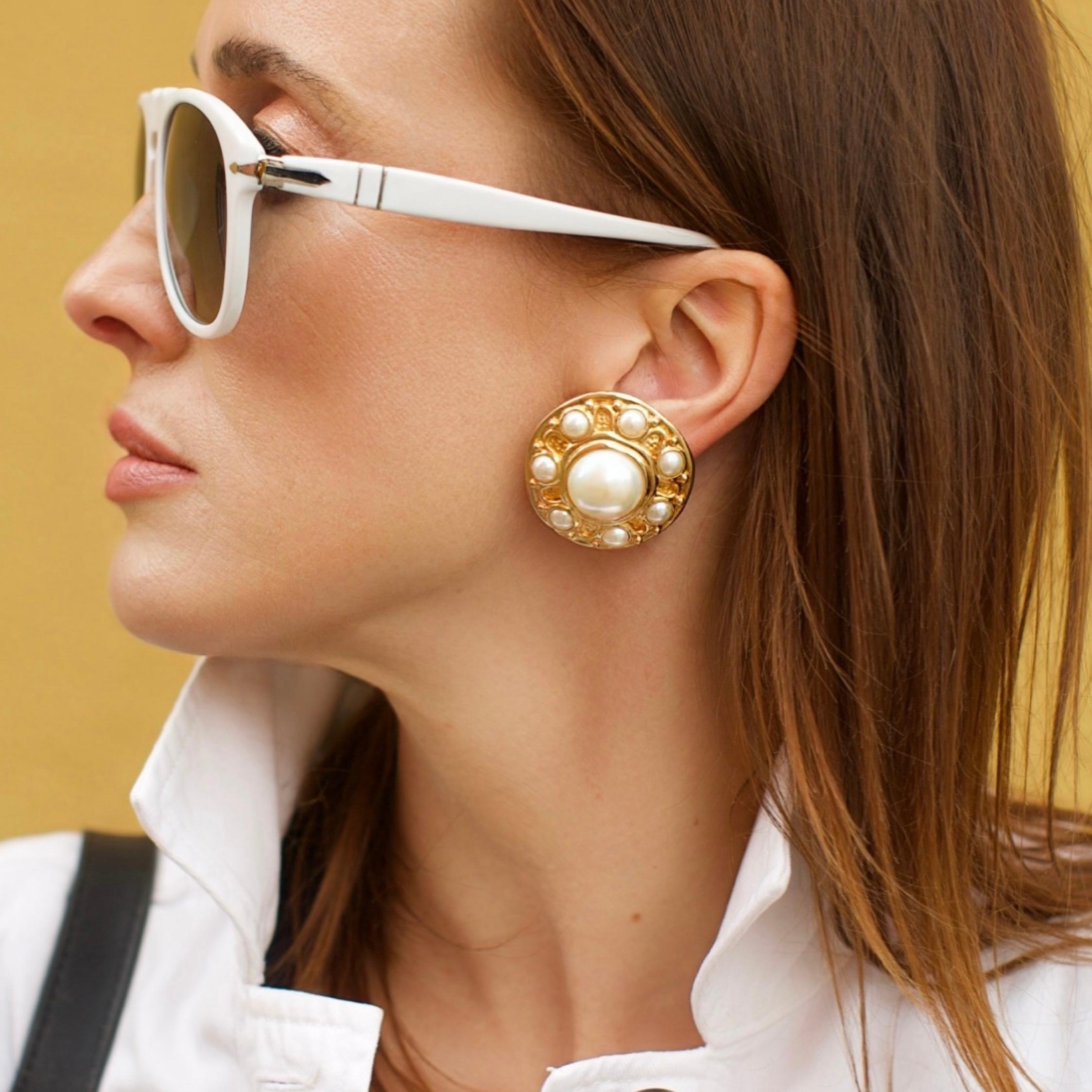 These vintage Christian Dior pearl clip-on earrings feature a bold 3.5cm circular gold-tone design embellished with luminous faux pearls. A statement piece of Dior costume jewellery.

Dimensions & Specifications:
Brand: Christian Dior
Type: Vintage