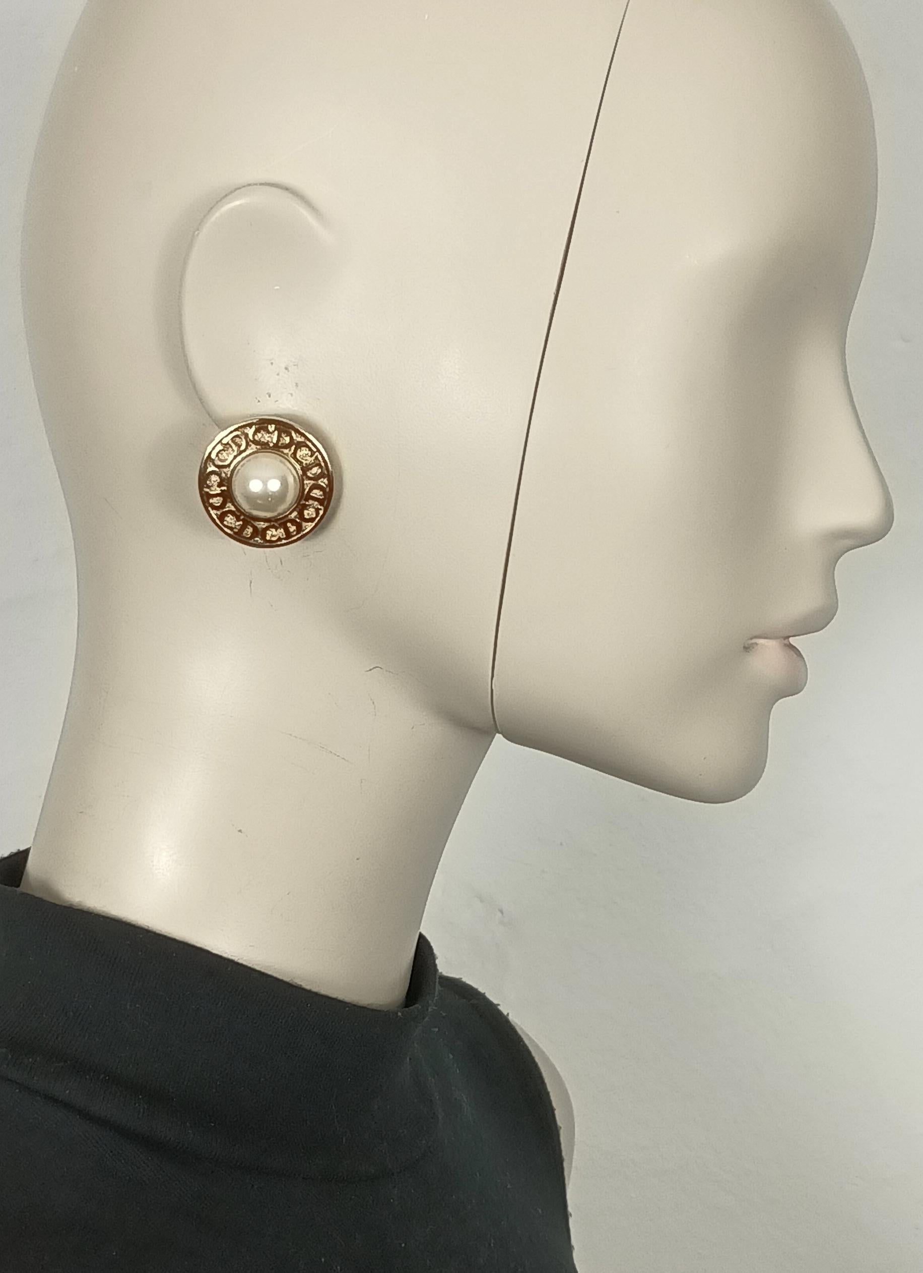 CHRISTIAN DIOR vintage gold tone clip-on earrings embossed with CD logos and embellished with a faux pearl at the center.

Embossed CHR. DIOR © Germany.

Indicative measurements : diameter approx. 2.6 cm (1.02 inches).

Weight per earring : approx.