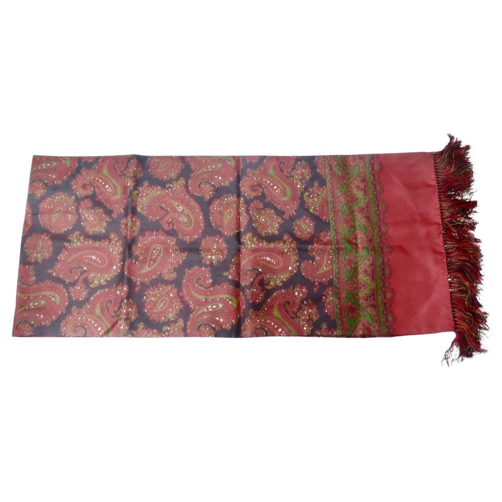 Do not miss out on this timeless Christian Dior scarf circa 1980s! A black 100% silk features a red, green and white paisley pattern complete with a red border throughout to create this closet staple. The finishing touch is the super fun fringe trim