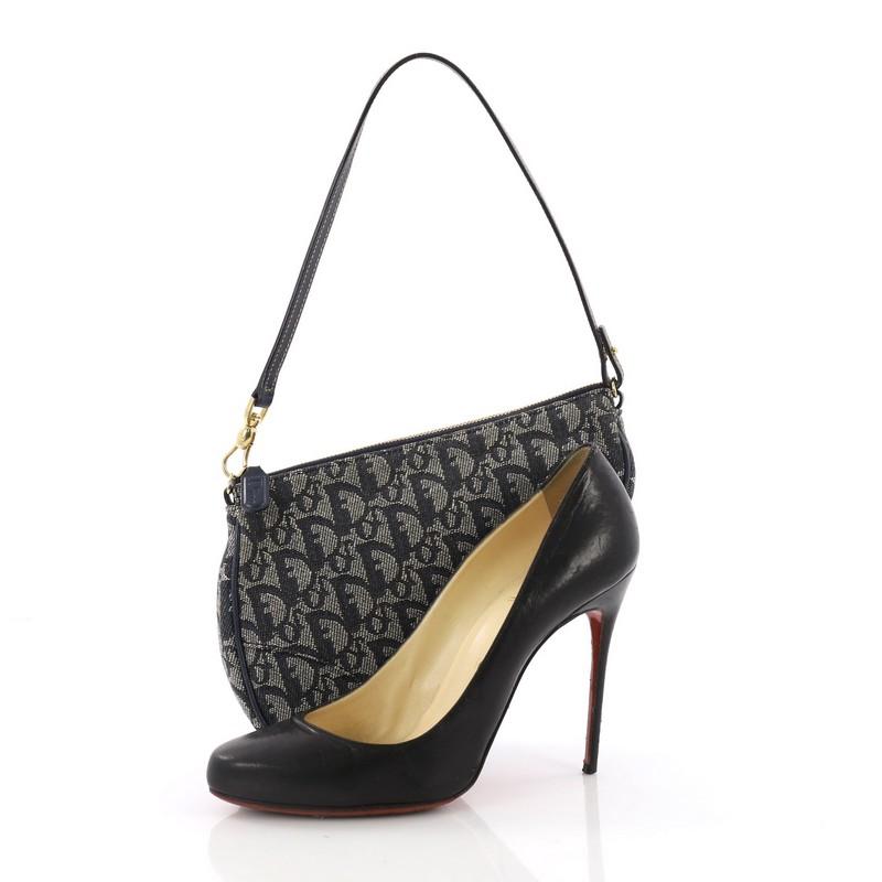 This Christian Dior Vintage Saddle Bag Diorissimo Canvas Mini, crafted from blue diorissimo canvas, features a top handle, a saddle-shaped silhouette, and gold-tone hardware. Its zip closure opens to a blue fabric interior. **Note: Shoe photographed