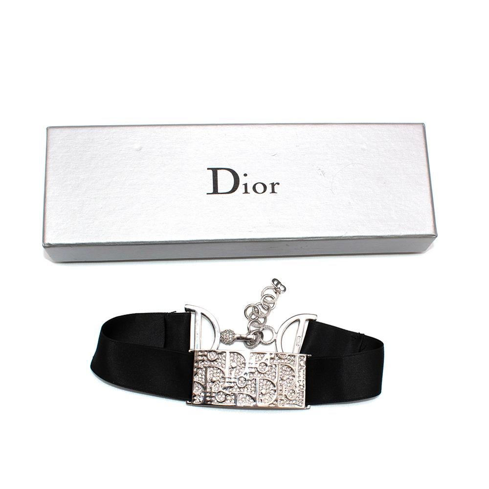 Christian Dior Vintage 1990's Silver Crystal Trotter Logo Choker

- Vintage 1990s collectable piece
- Silver metal choker
- Trotter logo plaque
- Set on a broad black satin ribbon
- Embellished 'D' chain link fastening 
- Elaborate rhinestone