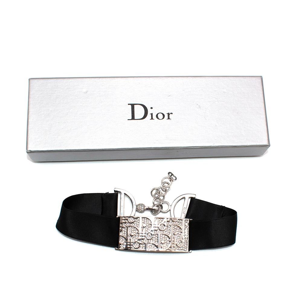 Christian Dior Vintage 1990's Silver Crystal Trotter Logo Choker

- Pièce de collection vintage des années 1990
- Tour de cou en métal argenté
- Plaque avec logo Trotter
- Monté sur un large ruban de satin noir
- Fermeture par chaîne en 'D' embellie