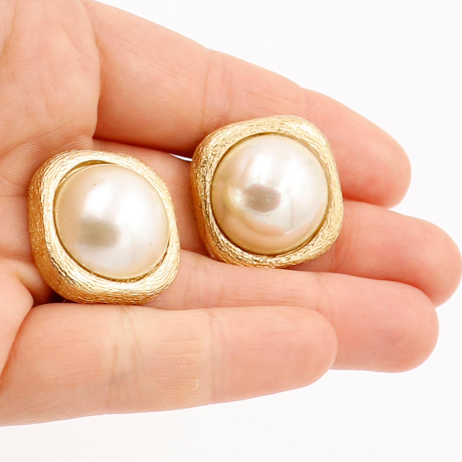 These vintage Christian Dior Earrings are in a textured gold plate with large center faux pearl. We love the earrings that have textured metal as they are so luxe and these measure 1