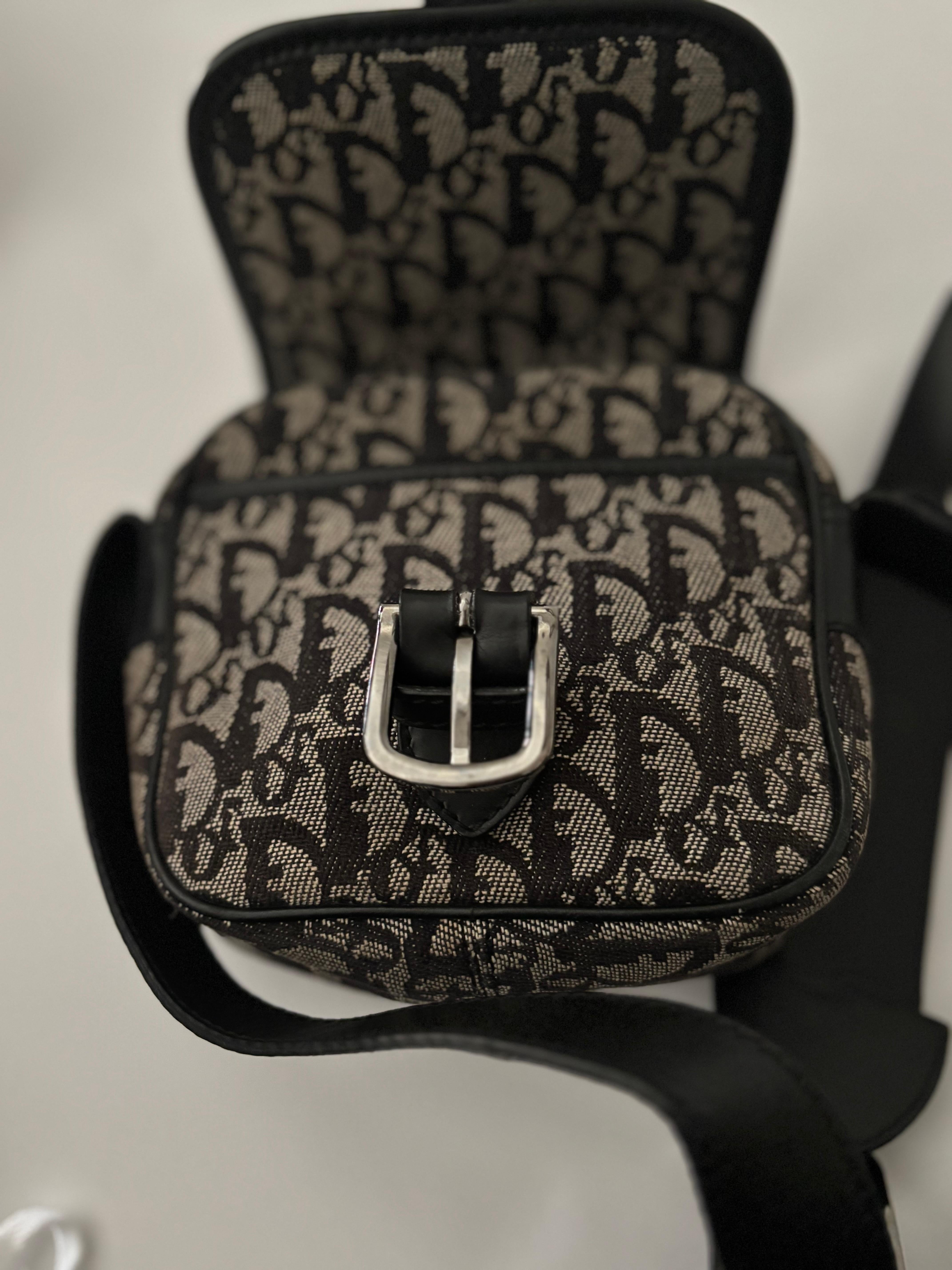 Te ofrecemos una trotadora vintage Christian Dior difícil de encontrar, fabricada en lona y piel de color negro y beige. Este bolso está en muy buen estado vintage, con pocos signos de desgaste. Hay arañazos superficiales en la piel, pero la lona,