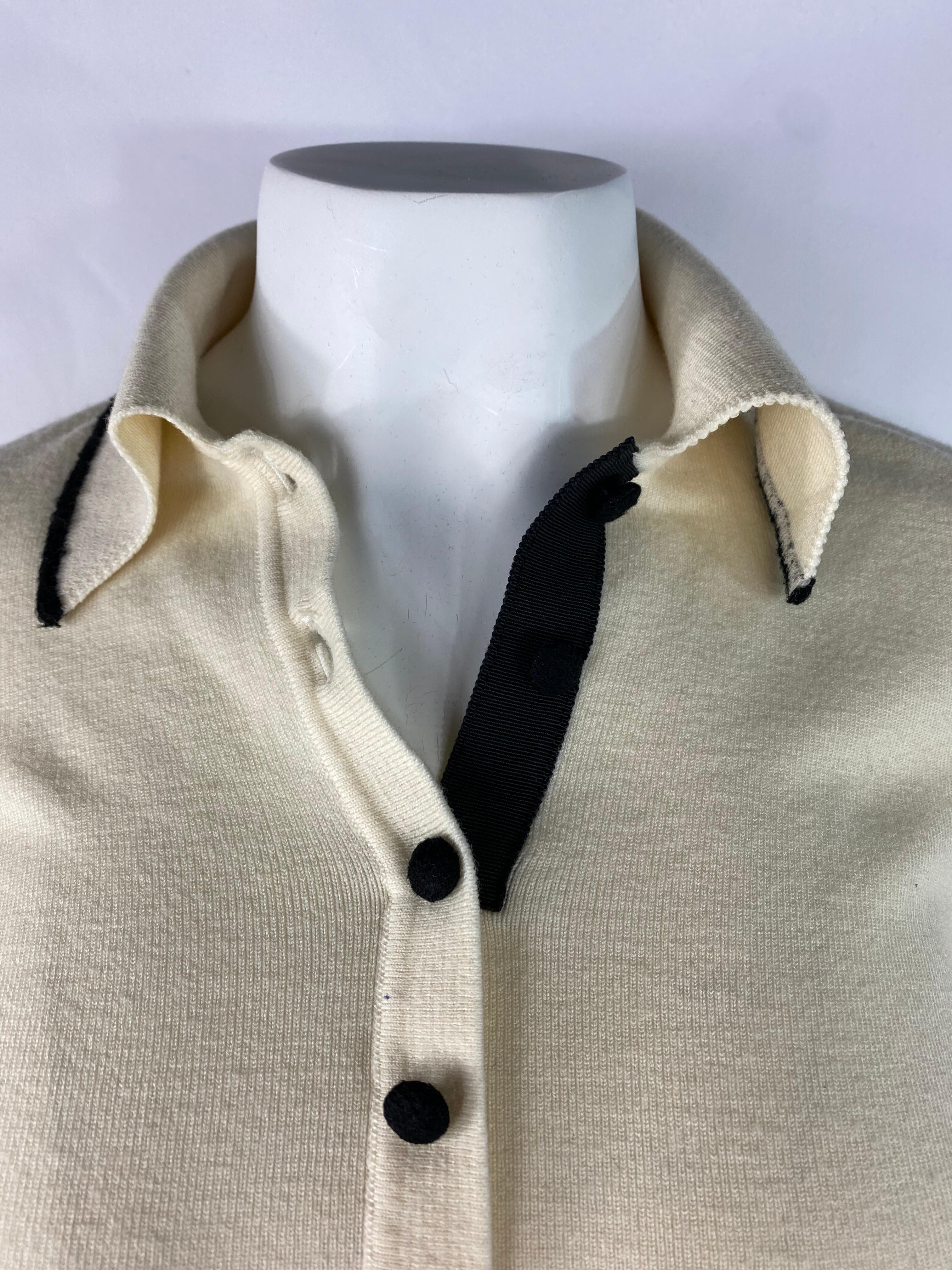 Product details:

Off white, cream and black wool blended top designed by Christian Dior in France. The top features collar, four front button closure, 3/4 sleeves length (16 inches long). The size is large.