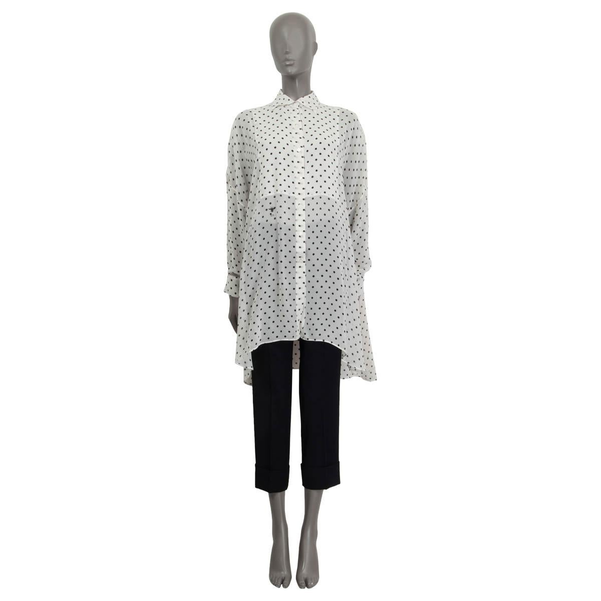 100% authentic Christian Dior sheer polka dot tunic shirt in white and black silk (assumed because tag is missing). Features batwings and an oversized fit. Has long sleeves and the 'CD' logo on the front. Opens with seven buttons on the front.