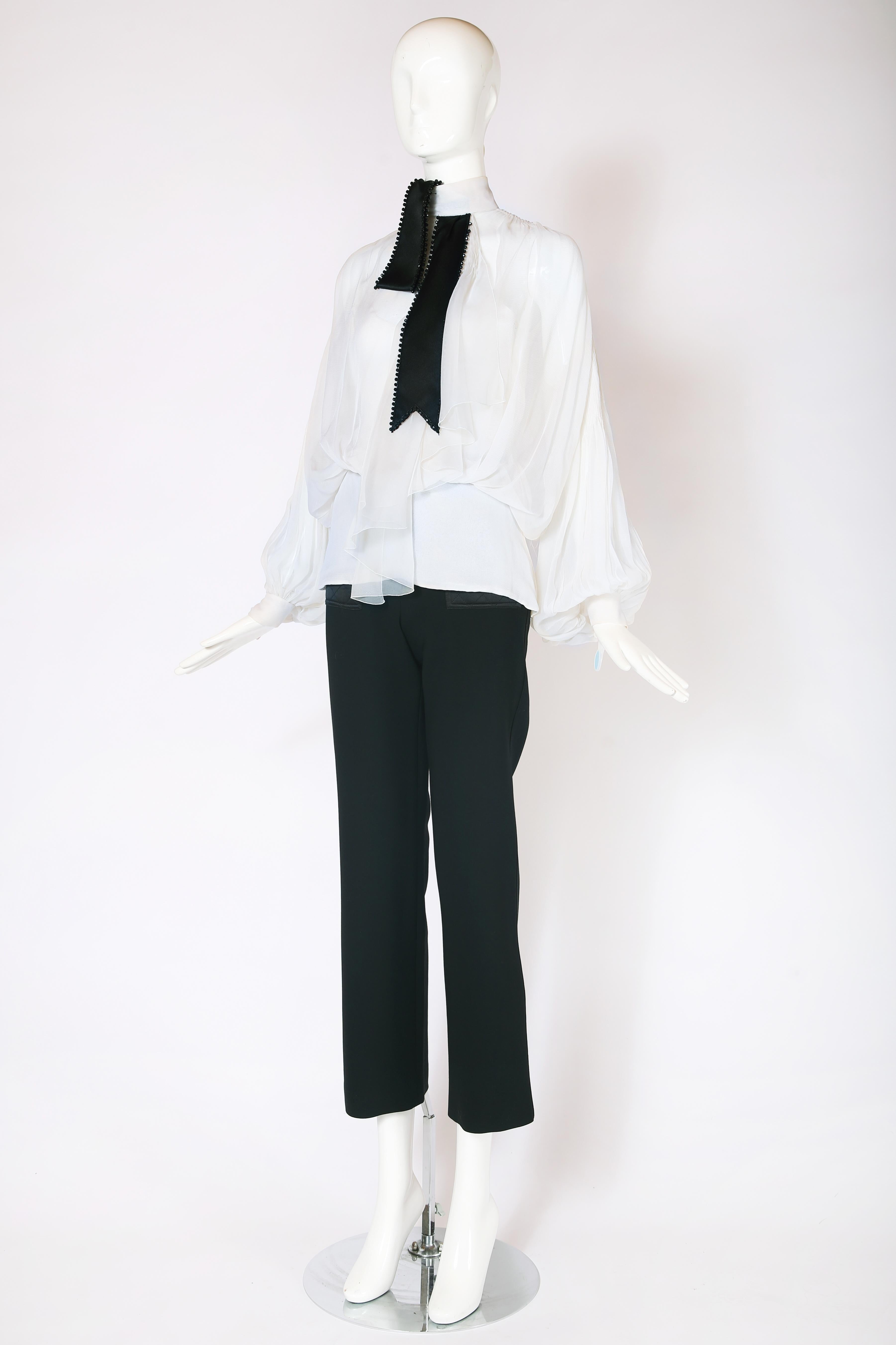 2001 F/W Christian Dior demi-couture sheer white chiffon blouse No. 16855. Blouse features mini pleating design detail at the back of the shoulder and sleeves, fitted waist yoke that fastens with side zipper, a black satin faux neck tie with black