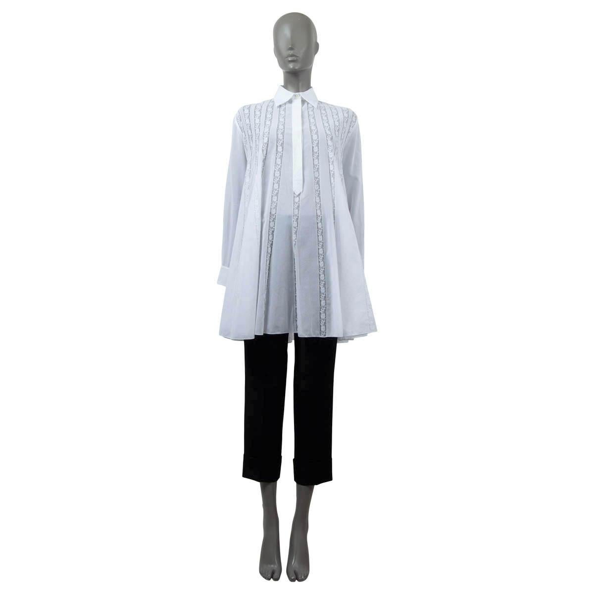 100% authentic Christian Dior 2018 long sleeve A-line lace trim tunic blouse in white sheer cotton. The design features a concealed button-line and floral lace panels. Has been worn and is in excellent condition. 

2018