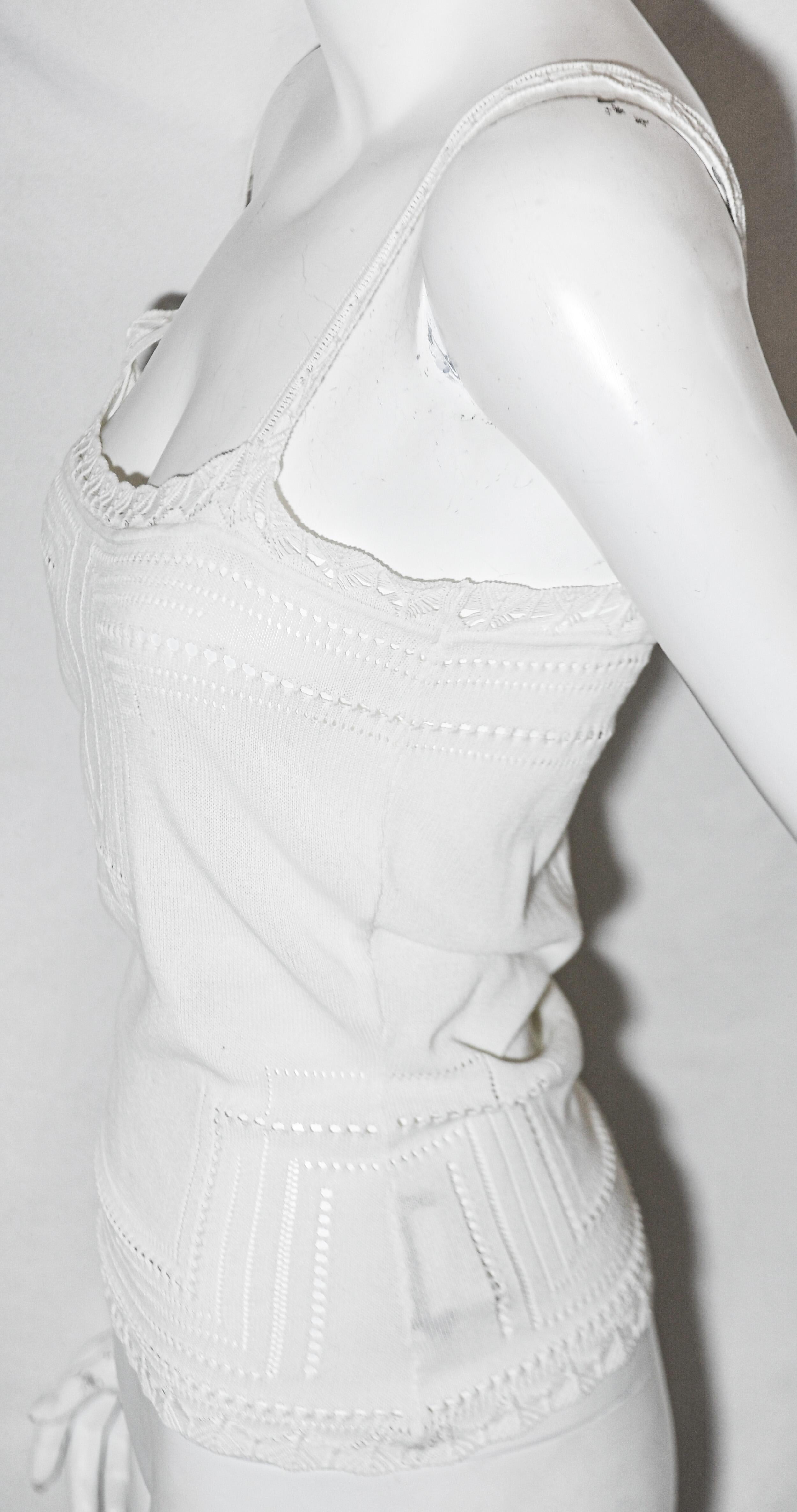 Christian Dior white cotton crochet knit camisole can be worn by itself with a pair of jeans or it can be worn under  a jacket, but why cover such a beautiful top! This top has a geometric peek a boo design throughout trimmed with a scalloped border