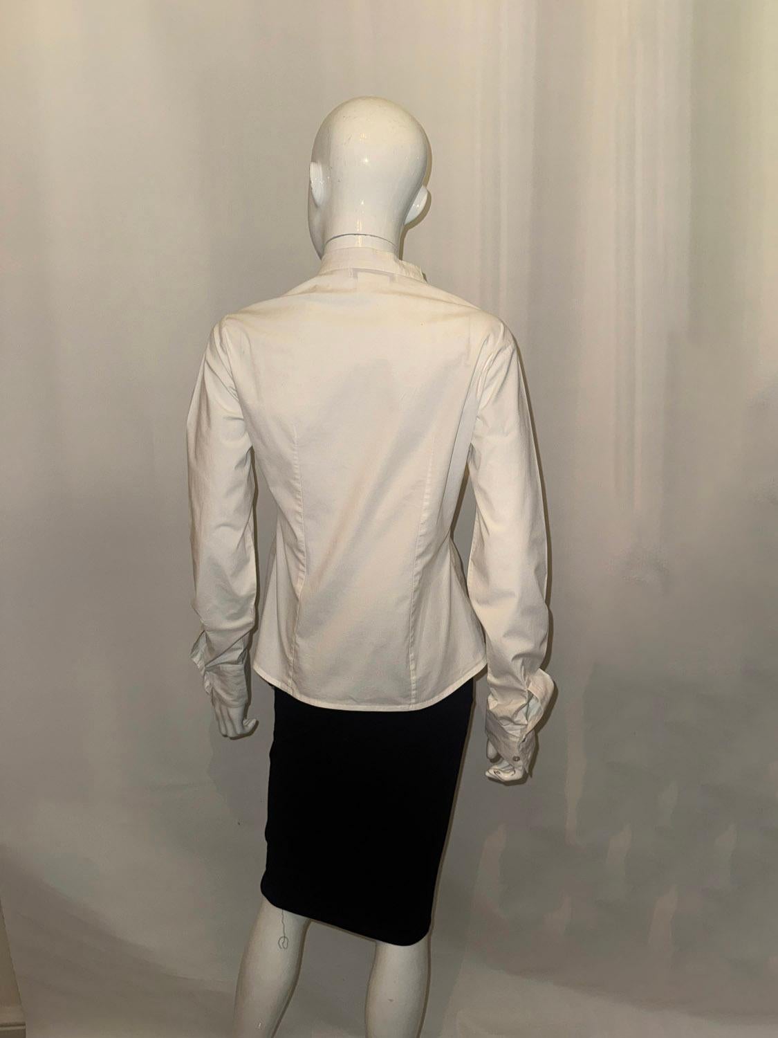  Ein schickes weißes Baumwollhemd / Bluse von Christian DIor. 
Die Bluse ist kragenlos und hat zwei Knopfmanschetten und eine Knopföffnung vorne. Alle Knöpfe tragen den Namen Dior. 
UK Größe 14 , US 10. Maße Oberweite bis zu 38'' Länge 23''
