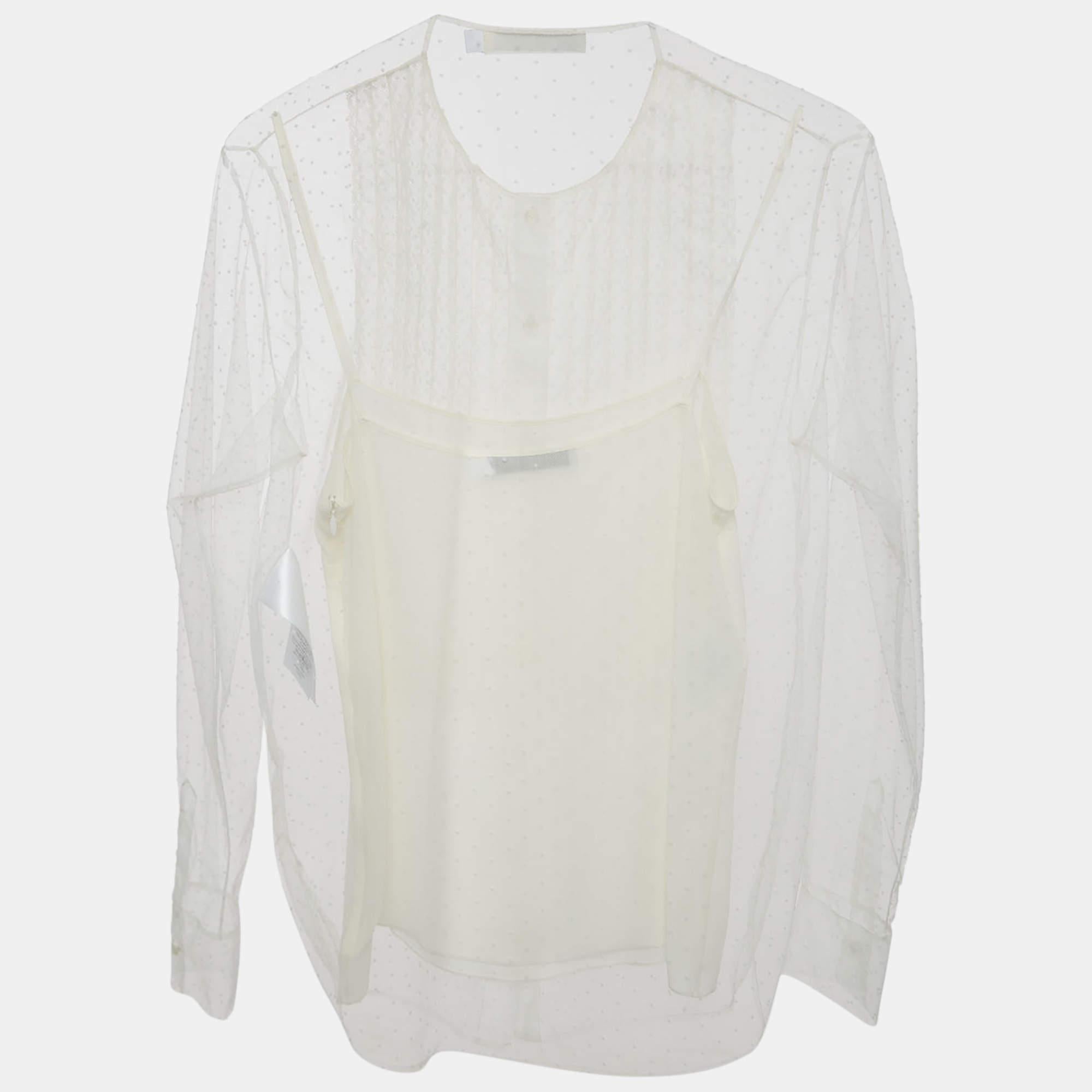 The Christian Dior blouse is an ethereal garment featuring delicate white tulle adorned with subtle, elegant dots. The blouse combines a timeless design with modern grace, showcasing Dior's iconic craftsmanship. Its sheer fabric and intricate