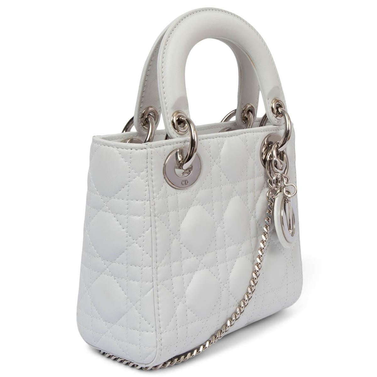 100% authentic Christian Dior Mini Lady Dior shoulder bag in white smooth calfskin with signature Cannage quilting. Silver-finish metal hardware and the 'D.I.O.R.' charms complete and illuminate its silhouette. Featuring a thin, removable leather