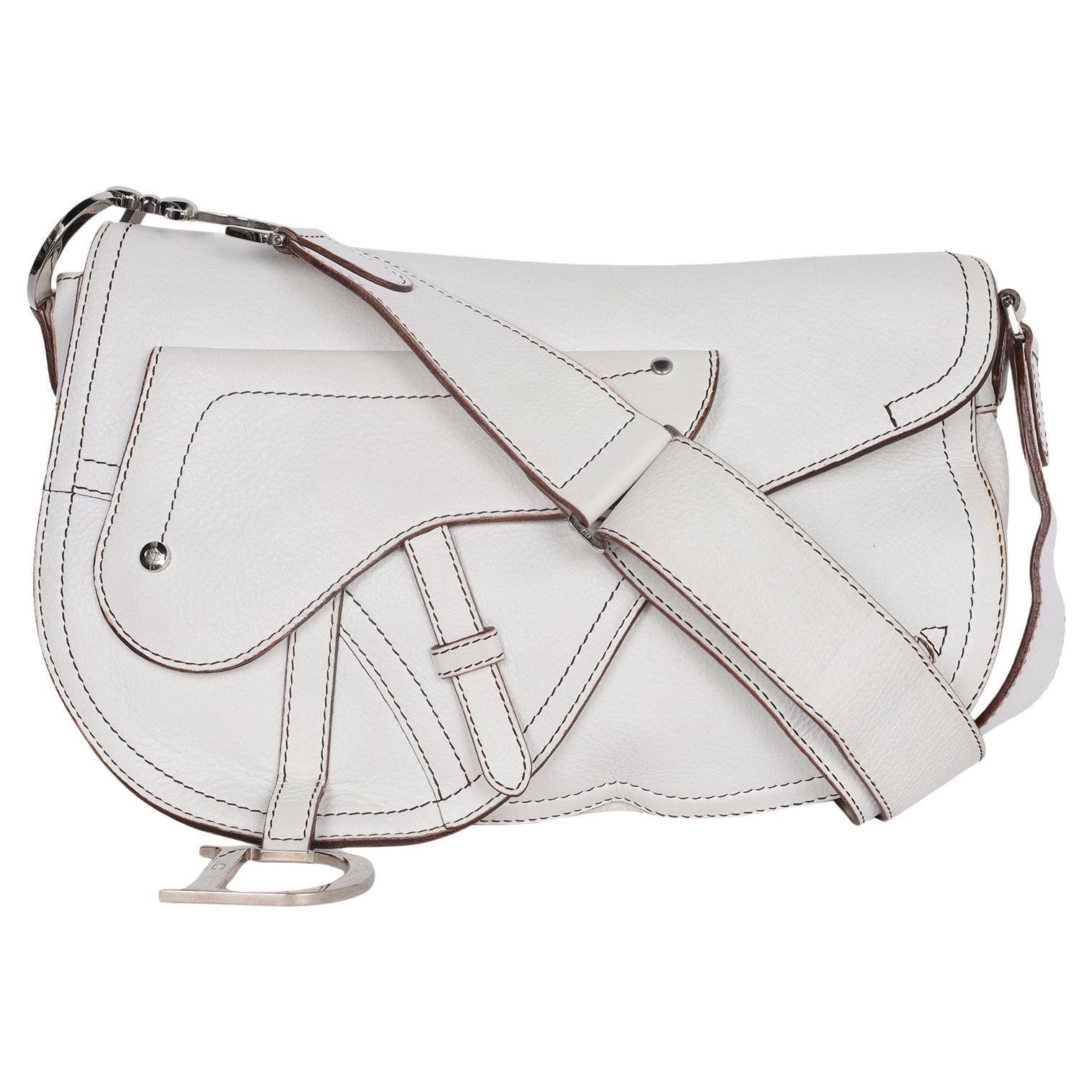 Authentic, pre-loved Christian Dior White Leather Saddle Messenger Crossbody Bag. Features great design elements with durable white leather in the now iconic Dior saddle bag with a prominent decorative frontal zipper pocket. It has extensive leather