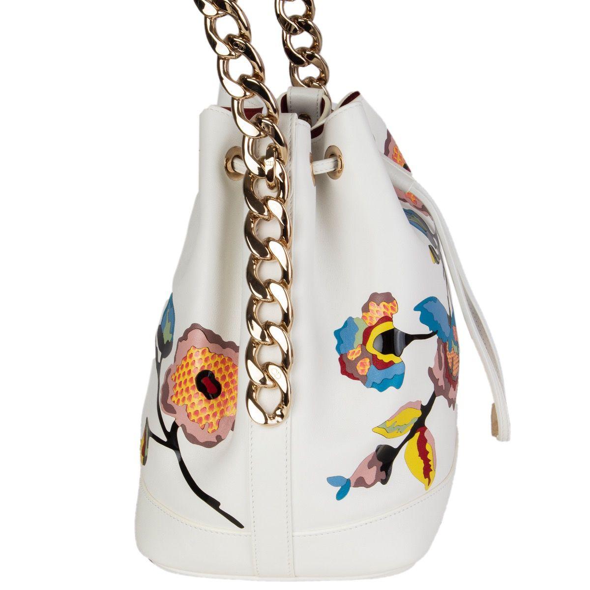 Christion Dior bucket form the Cruise 16 collection in off-white calfskin with embossed multicolor flower featuring pink and yellow snakeskin details. Open with a drawstring on top and is lined deep red calfskin with one zip pocket against the back