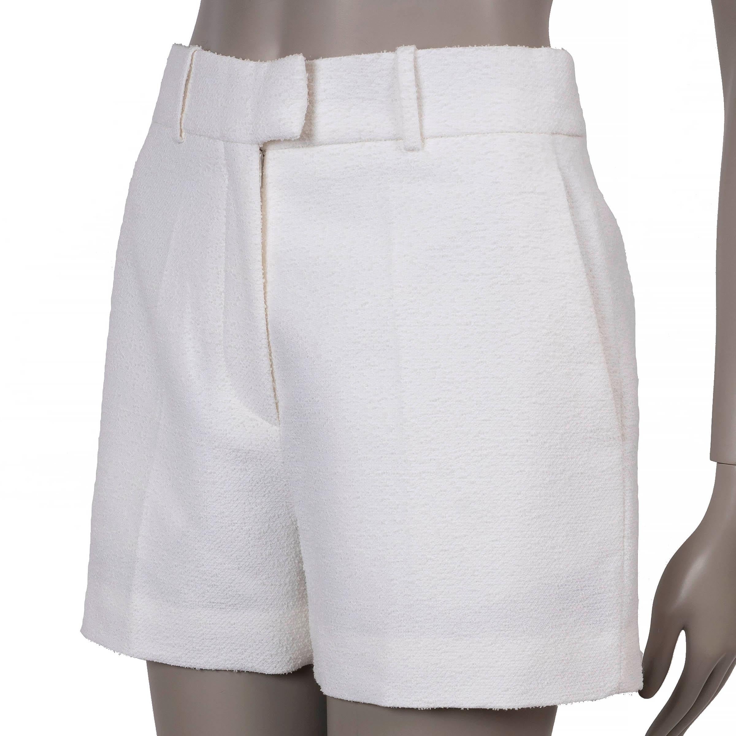 Questi pantaloncini 100% autentici di Christian Dior in lana bouclé crema (70%), cotone (23%) e poliammide (7%) incarnano una sartoria raffinata con un tocco moderno. Progettati con una silhouette strutturata e una lunghezza corta, presentano pieghe