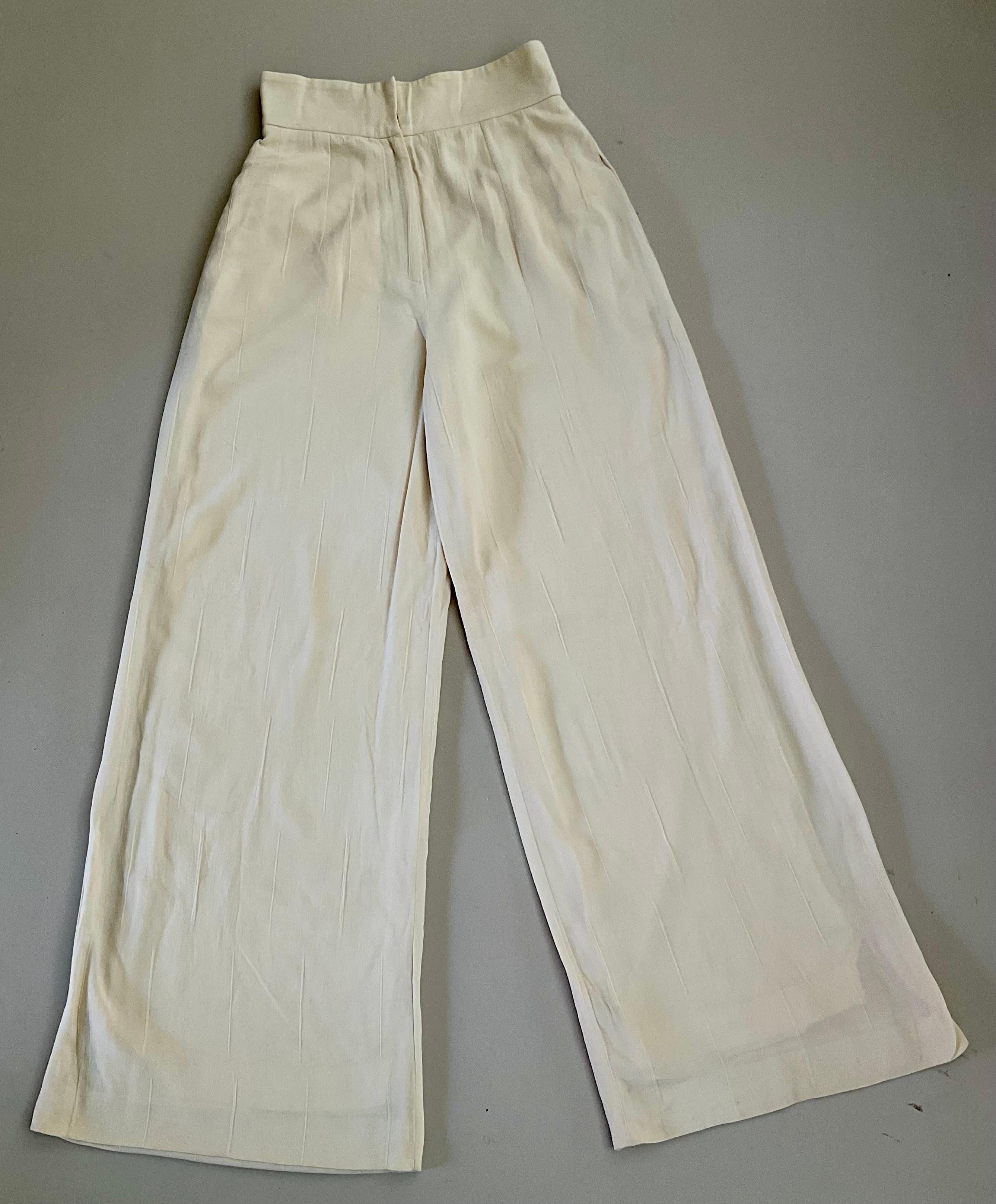 Brillez avec cette véritable pièce de collection de Christian Dior, datant des années 1990 et en excellent état. Usés. Cet élégant pantalon à jambe large est doté d'une luxueuse doublure 100 % soie et d'un tissu magnifiquement drapé au motif tissé