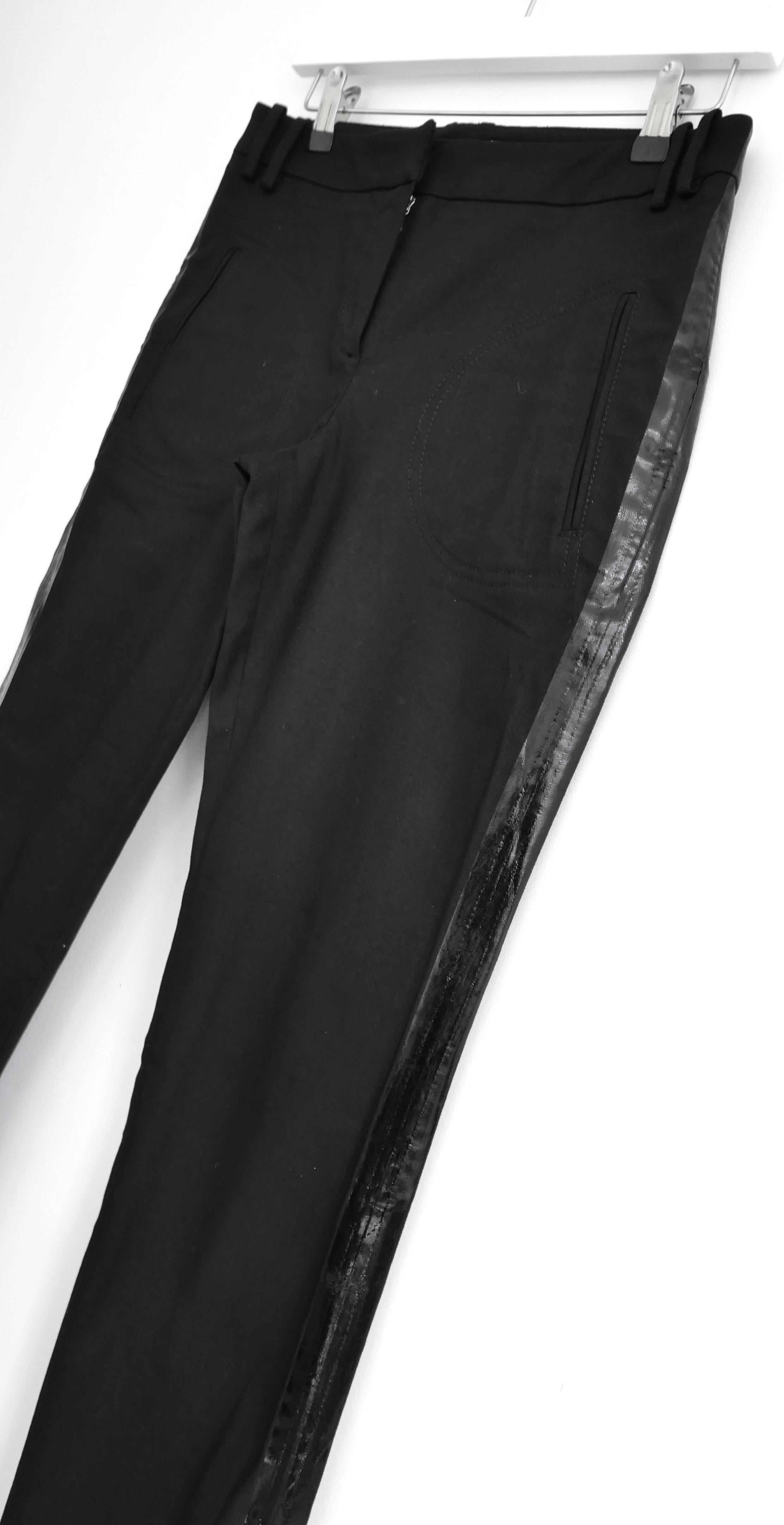 Chic and sleek Christian Dior PVC trim black trousers from John Galliano’s Fall 2006 collection - look 9 on the runway. Unworn. Made from black cotton and lycra with glossy painted PVC strips to the sides. They have straight legs, mid rise waist and