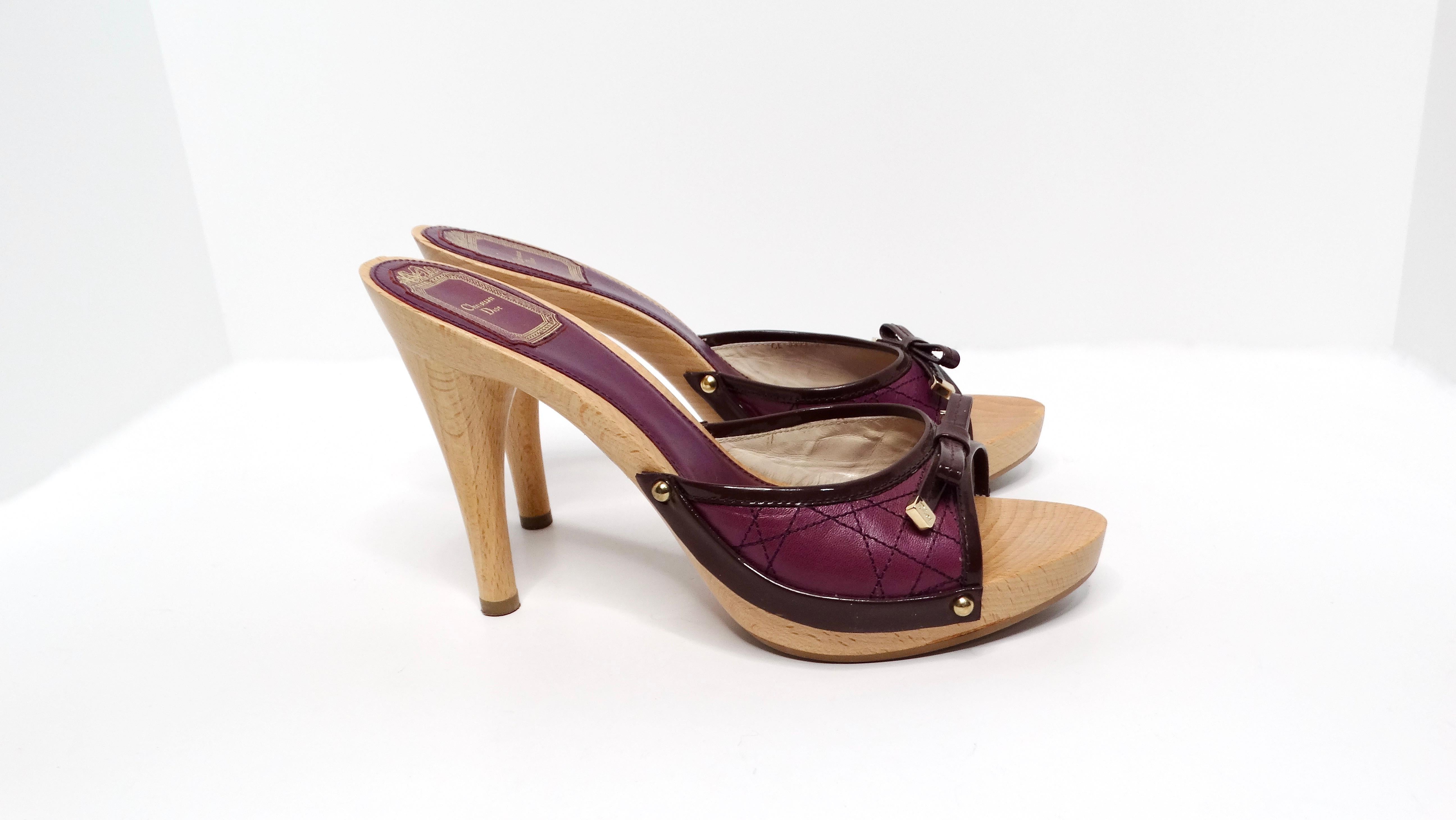 Step into the iconic era of Y2K fashion with the Christian Dior Purple Leather & Wooden Heeled Sandals. These striking sandals feature a stylish cloglike wooden platform heel, perfectly embodying the playful yet chic aesthetics of the time. The toe