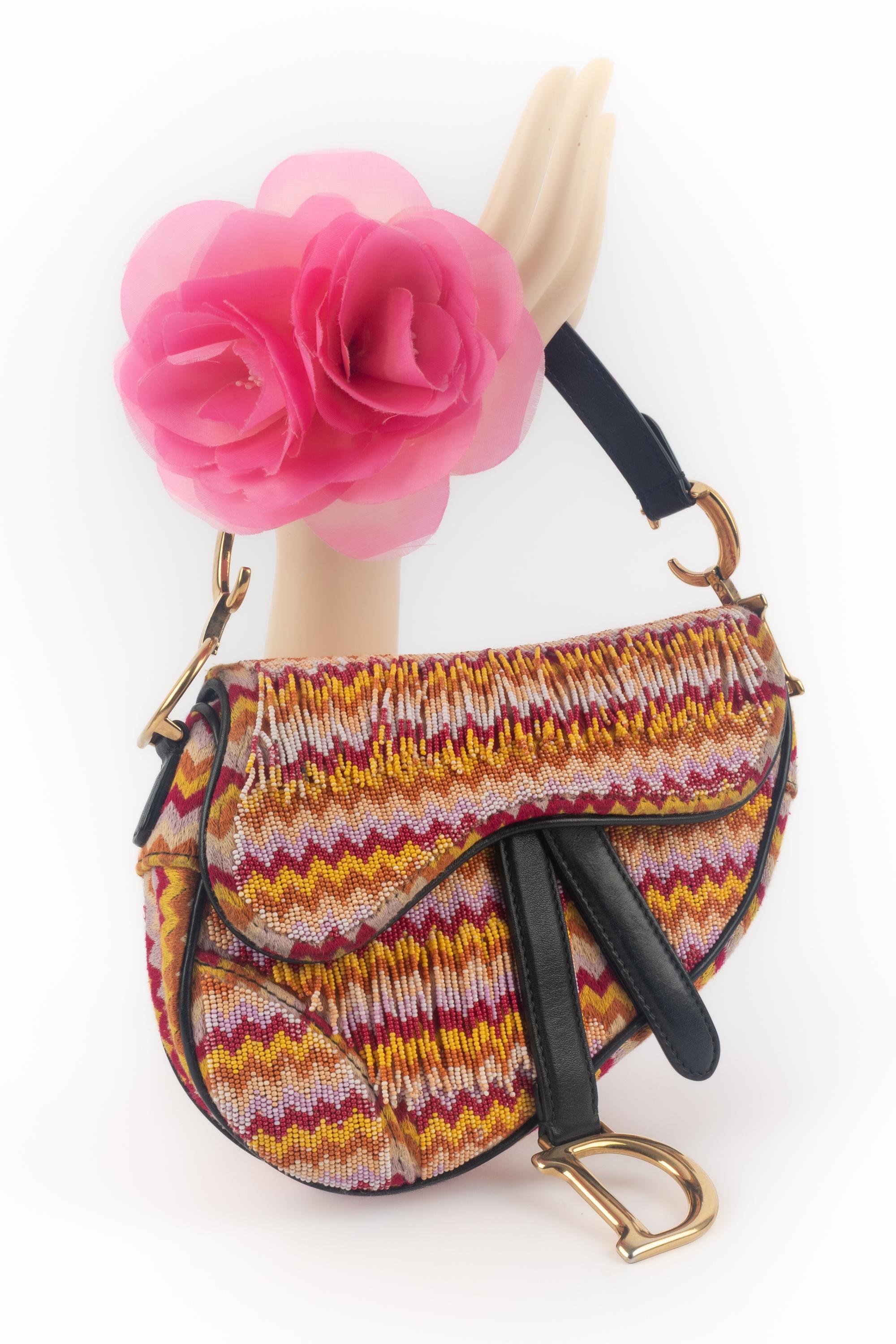 DIOR - (Made in Italy) Borsa 'Saddle' interamente ricamata con un motivo multicolore e impreziosita da perle in tinta. Interno, manico e festello in pelle nera ed elementi in metallo dorato. Un pezzo con un numero di serie. Una collezione 2018 sotto