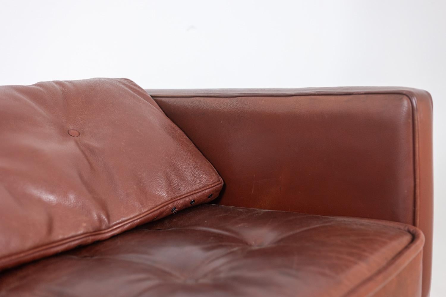 Christian Duc, par.

3-seater leather sofa, “Orwell” model, chocolate color and rectangular shape, composed of a large padded seat with two padded cushions to place on the back or on the armrests. Black lacquered metal base ending in a