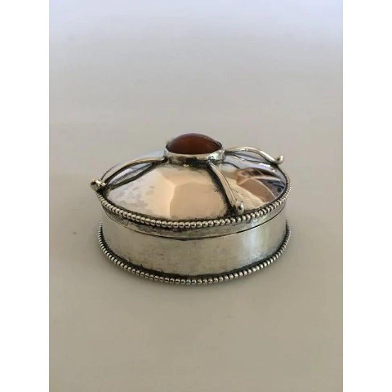 Christian Fjerdingstad pill box in 826 silver ornamented with an Amber stone.

Measures 2.2 cm Height (0 55/64