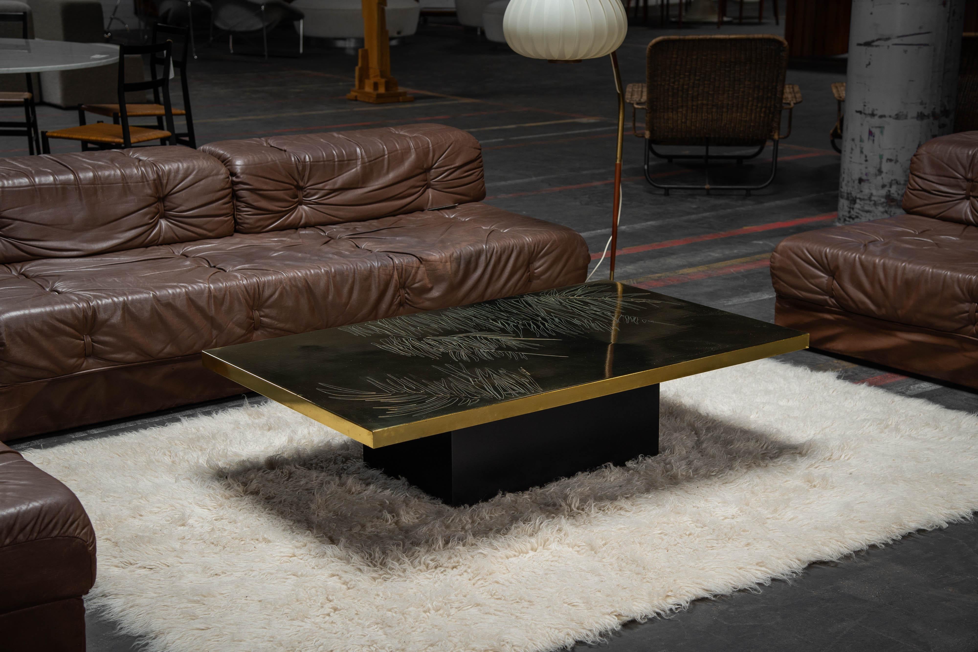 Table basse décorative conçue et fabriquée par Christian Krekels en Belgique en 1977. La table est dotée d'une solide base en bois noir et d'un magnifique plateau en laiton aux couleurs chaudes, orné d'un magnifique motif de feuilles florales. La