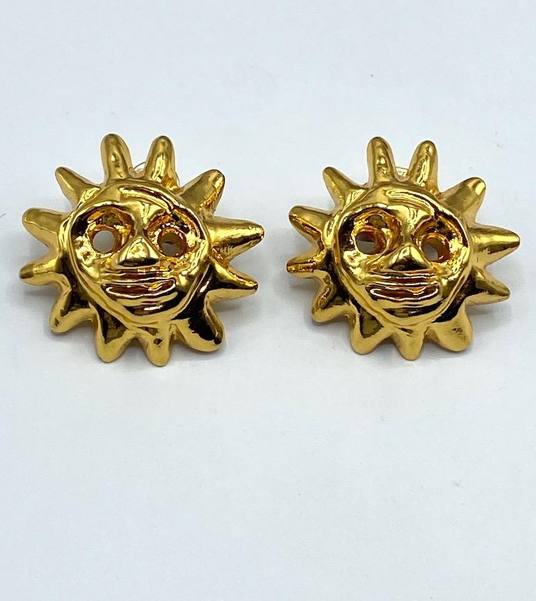 A beautiful and iconic pair of 1990s Christian Lacroix smiling sun face earrings. The sun face is one of Lacroix's favorite motifs. Each earrings measures a large 1.75 inches in diameter and .63 of an inch deep not including the clip back. The
