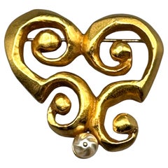 Christian Lacroix anni 
90, oro satinato con spilla astratta di perle