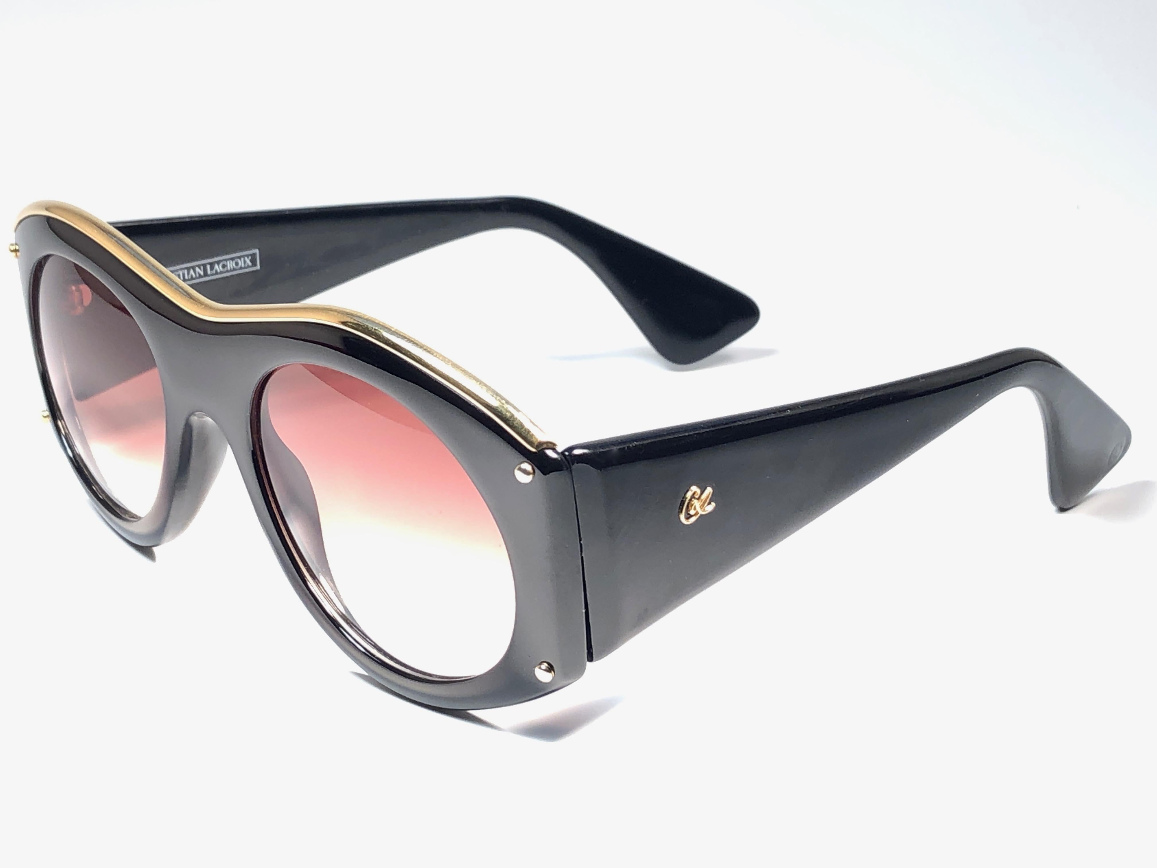 Rare pair of New vintage Christian Lacroix sunglasses.   

Black & gold frame holding a pair of spotless brown gradient lenses. 

New, never worn or displayed. 

Made in France.