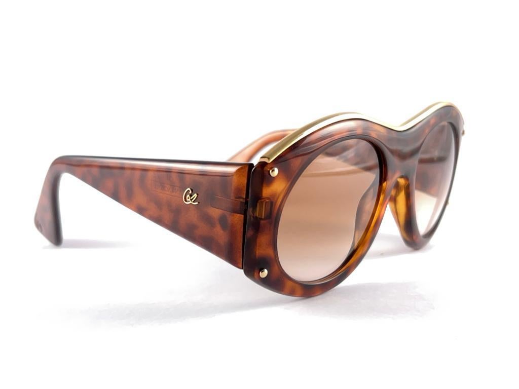 Rare pair of New vintage Christian Lacroix sunglasses.   
Translucent Tortoise & gold frame holding a pair of spotless brown gradient lenses. 

New, never worn or displayed. 
this item may show minor sign of wear due to storage



Made in