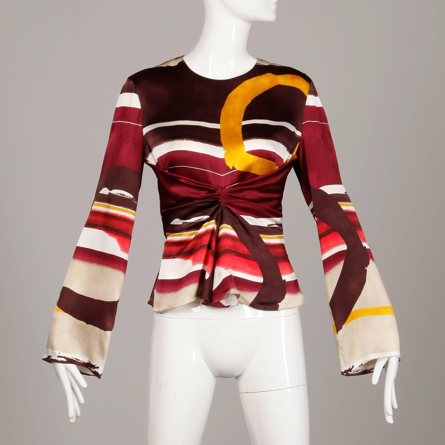 Gorgeous Christian Lacroix printed silk top with bell sleeves. Unlined with side zip closure and rear hook closure. 100% silk. The marked size is 42, and the top fits like a size medium. The bust measures 36