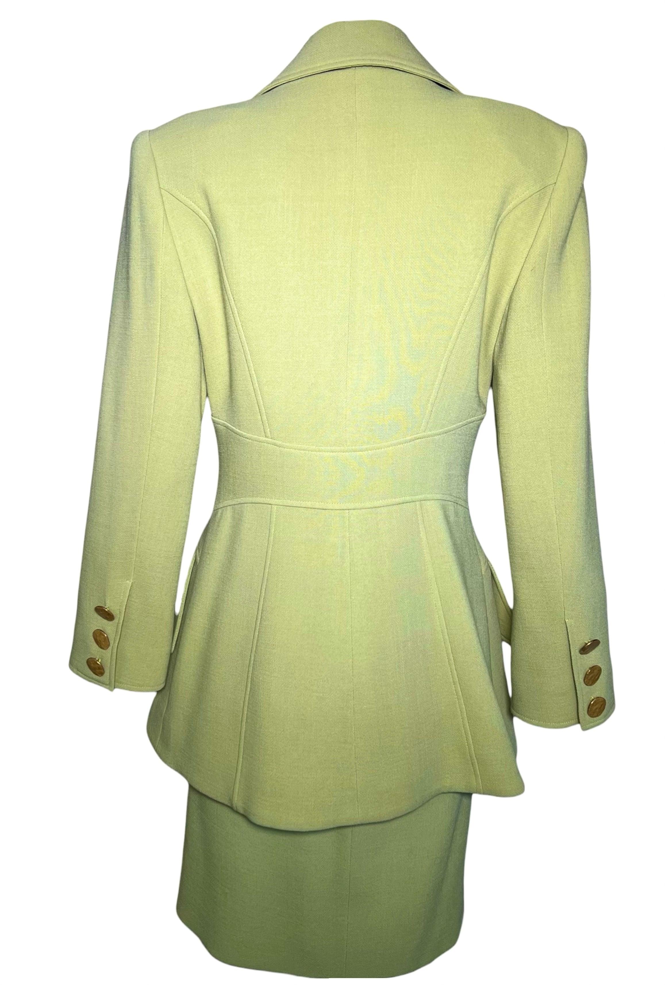 Fabulous avocado green skirt suit by Christian Lacroix. Exquisite tailoring. Double breasted with notched peak lapels. Gold-toned medallion buttons in the style of ancient coins with 