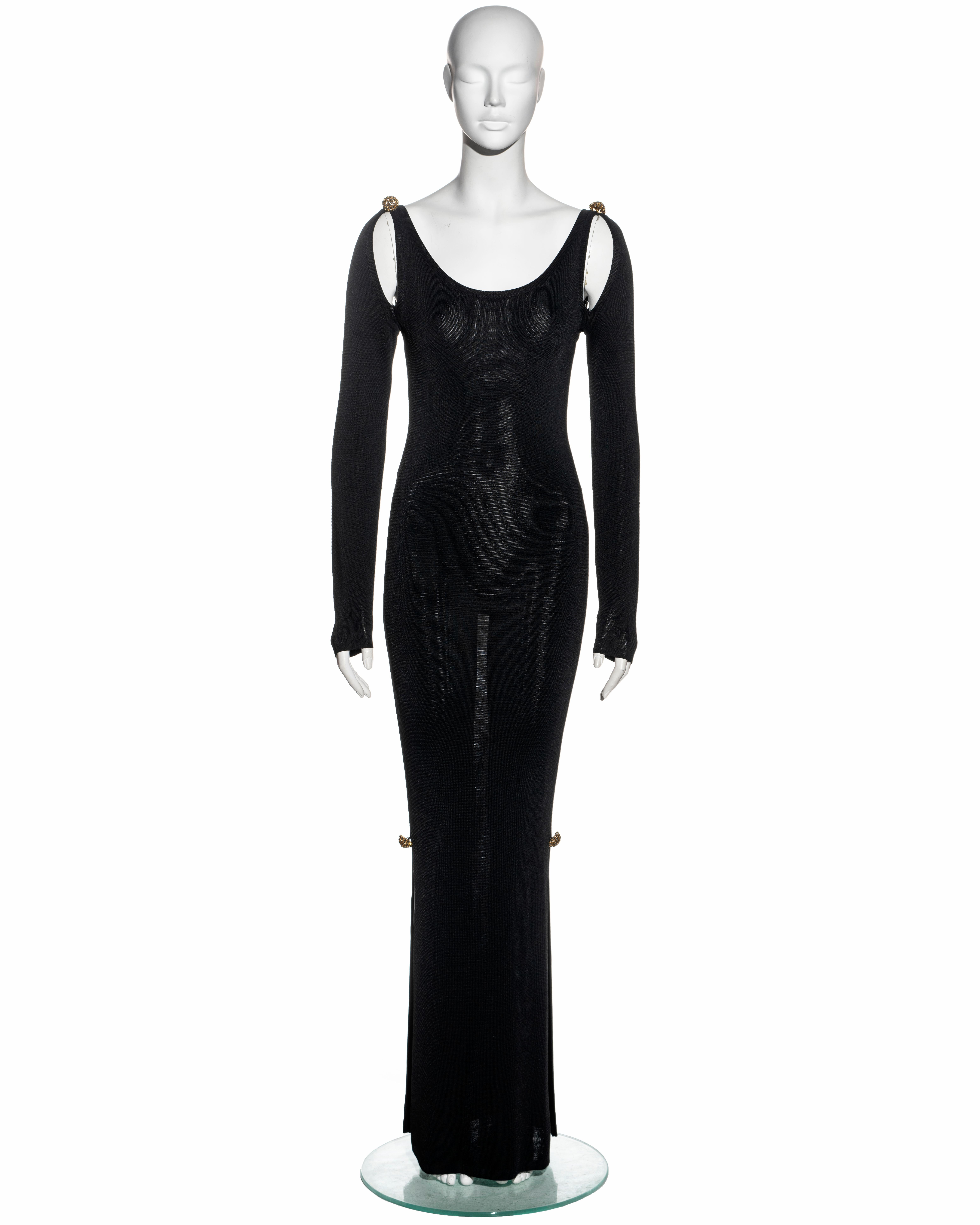 ▪ Christian Lacroix evening dress
▪ Sold by One of a Kind Archive
▪ Constructed from black knitted fabric (probably acetate or viscose)
▪ Gold ornaments with crystals on the shoulder and leg slits 
▪ Size Small - Medium
▪ Fall-Winter 1992

All