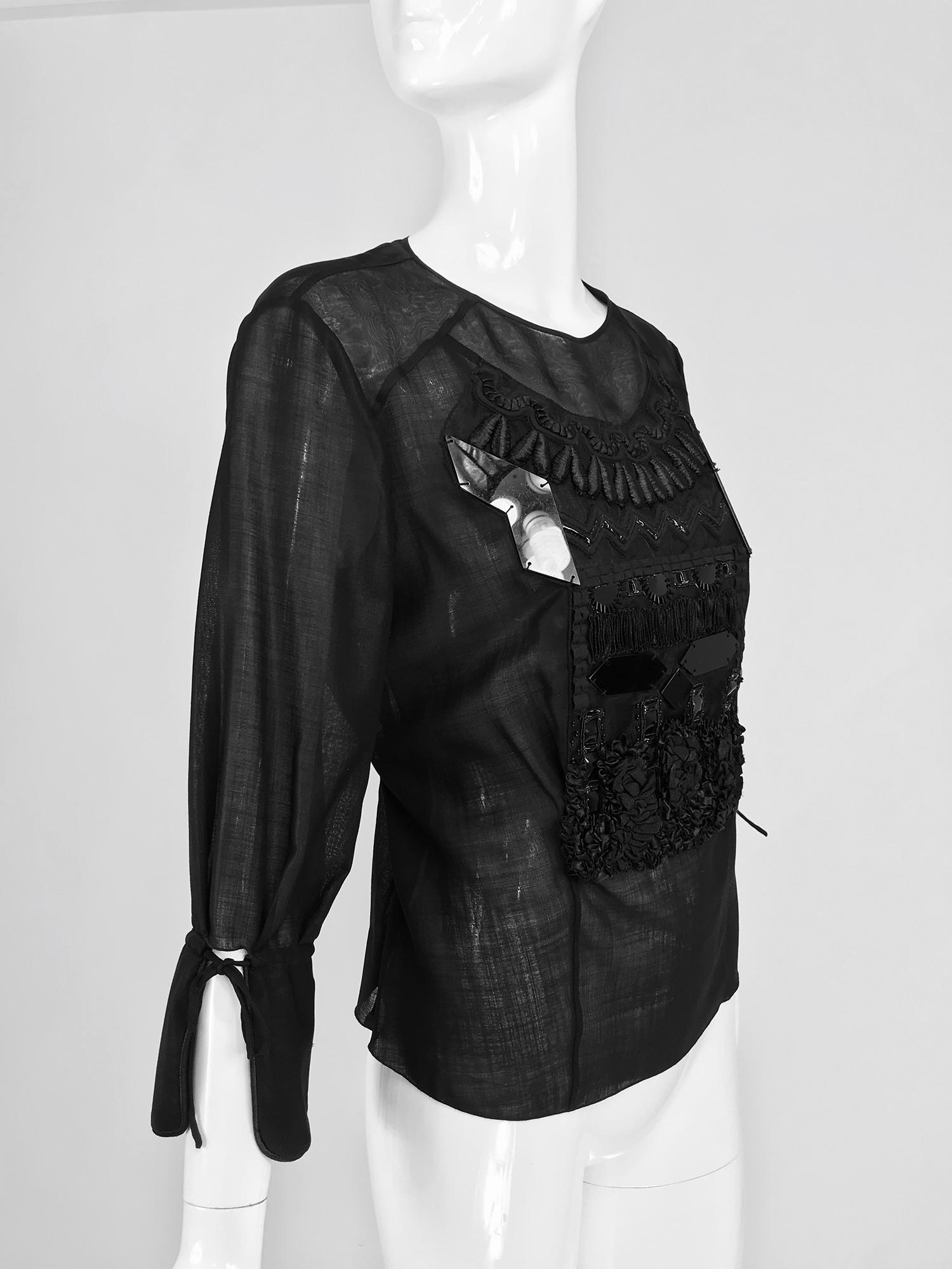 Christian Lacroix black silk organza embroidered and sequin appliqued blouse. This amazing blouse is a tribute to Lacroix's use of decoration as art. Pull on blouse with 3/4 length sleeves that have wide turn back cuffs and draw cord ties. The sheer