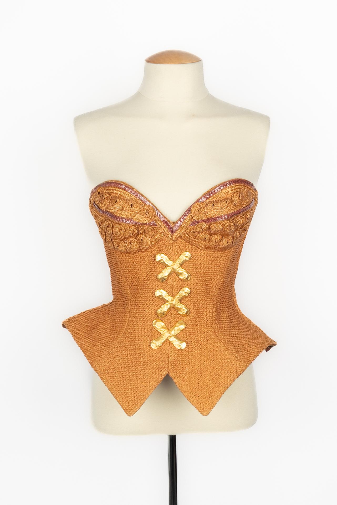 CHRISTIAN LACROIX - (Made in France) Raffia bustier top with fake cross buttons made of beaten golden metal. Size 36FR indicated. 1993 Spring-Summer Collection.

Condition:
Good condition

Dimensions:
Chest: 44 cm - Waist: 28 cm - Length: 40