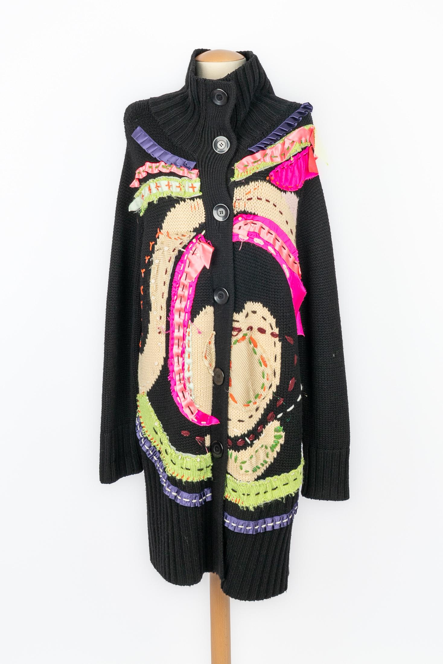 CHRISTIAN LACROIX - Long black wool cardigan ornamented with multicolored ribbons and threads. It comes with a scarf. Size XL indicated.

Condition:
Very good condition

Dimensions:
Shoulder width: 50 cm - Chest: 62 cm - Sleeve length: 70 cm -